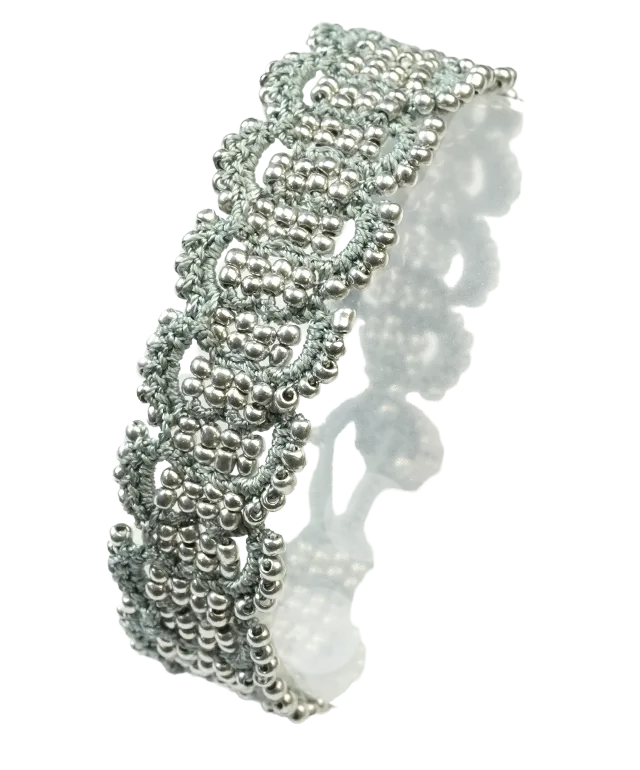 Jeune femme portant un bracelet en fil et perles, crocheté à la main, modèle Bark