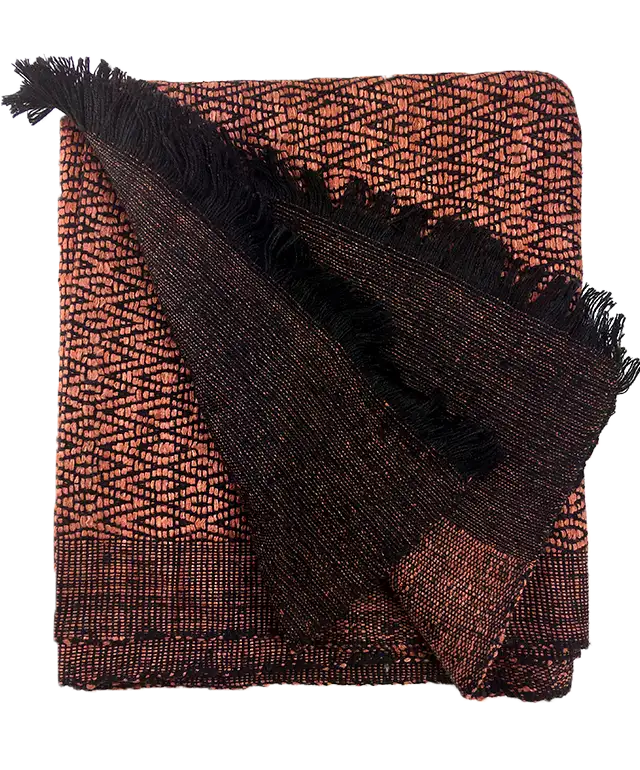 Smiling woman wearing a clay-coloured Eri Eshani wild silk stole with delicate motifs, illuminated by light