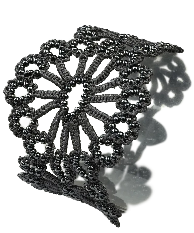 Close-up view of the slate bleue Hawa lace bracelet placed on a white pebble.