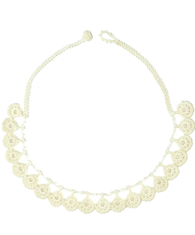 Eda lace necklace in ivory color set on gray pebbles