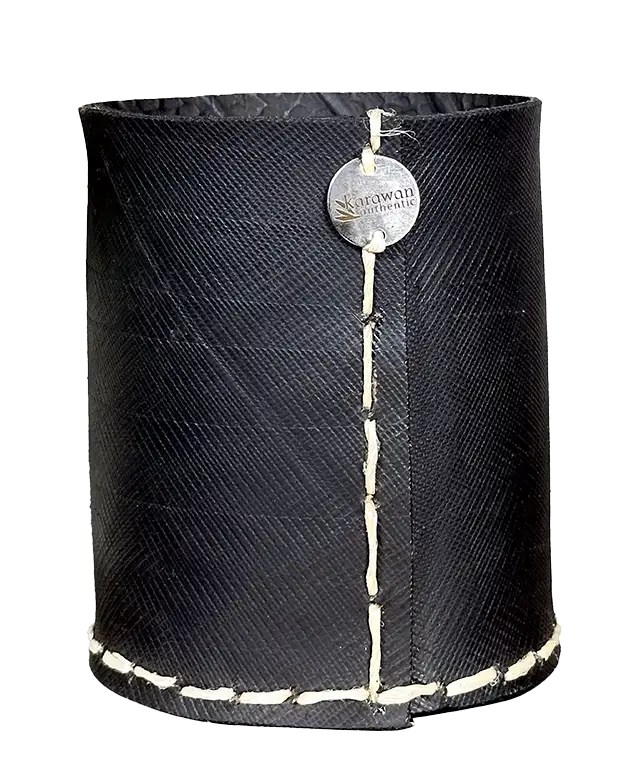 Moyen pot droit en pneu recyclé à côté de galets, sur un plateau en laiton