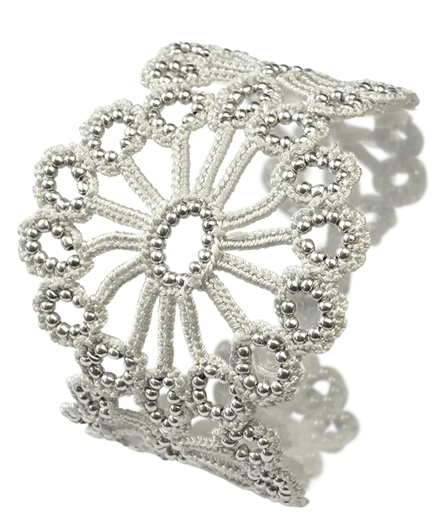 Handmade silver grey Hawa lace bracelet placed on a white background