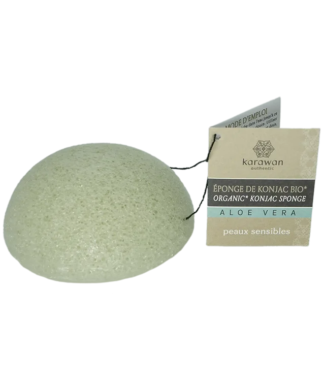 Éponge de konjac avec cordelette et étiquette carton affichant le logo Karawan posée sur une coupelle