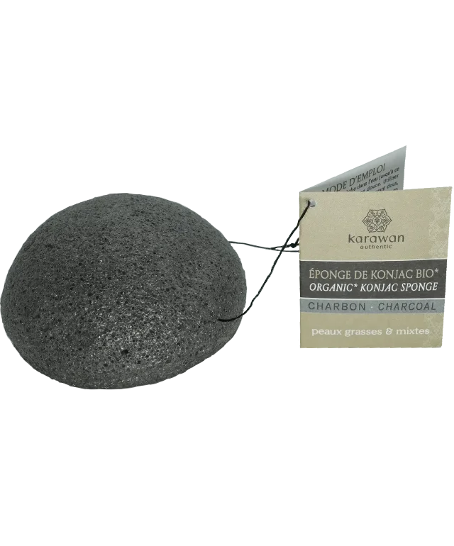 Éponge de konjac avec cordelette et étiquette carton affichant le logo Karawan posée sur une coupelle