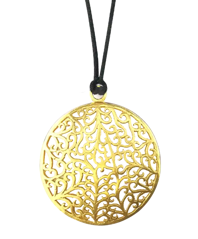 Pendentif en laiton de la gamme Jardin secret, vus en hauteur sur une surface à carreaux