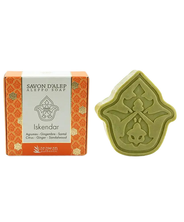 Iskendar scented Aleppo soap, petal-shaped and citrus-scented, next to its golden box