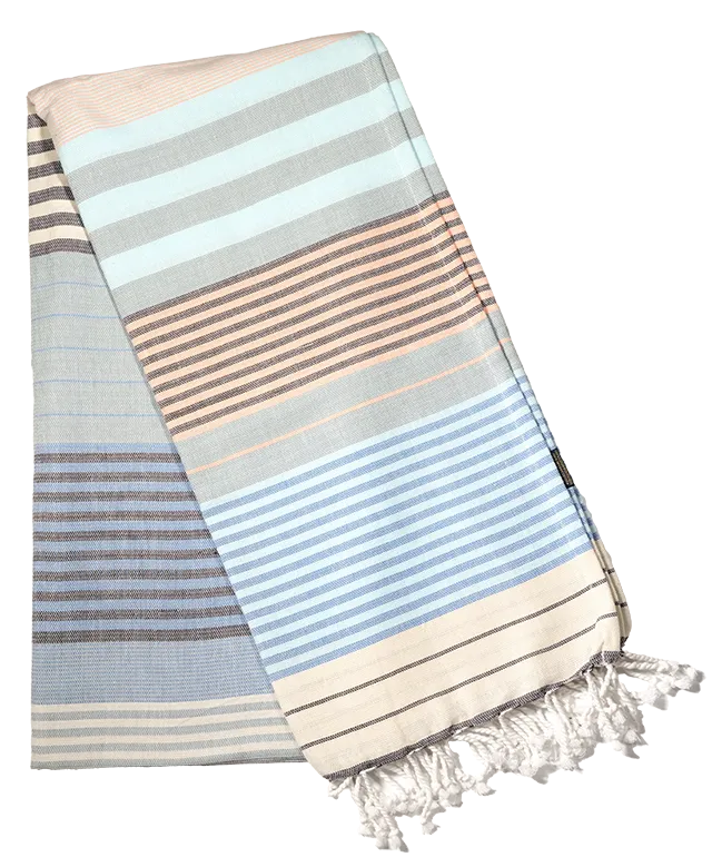 Fouta en coton Waves de la collection Sud disposée sur une chaise, les franges tombant sur le côté