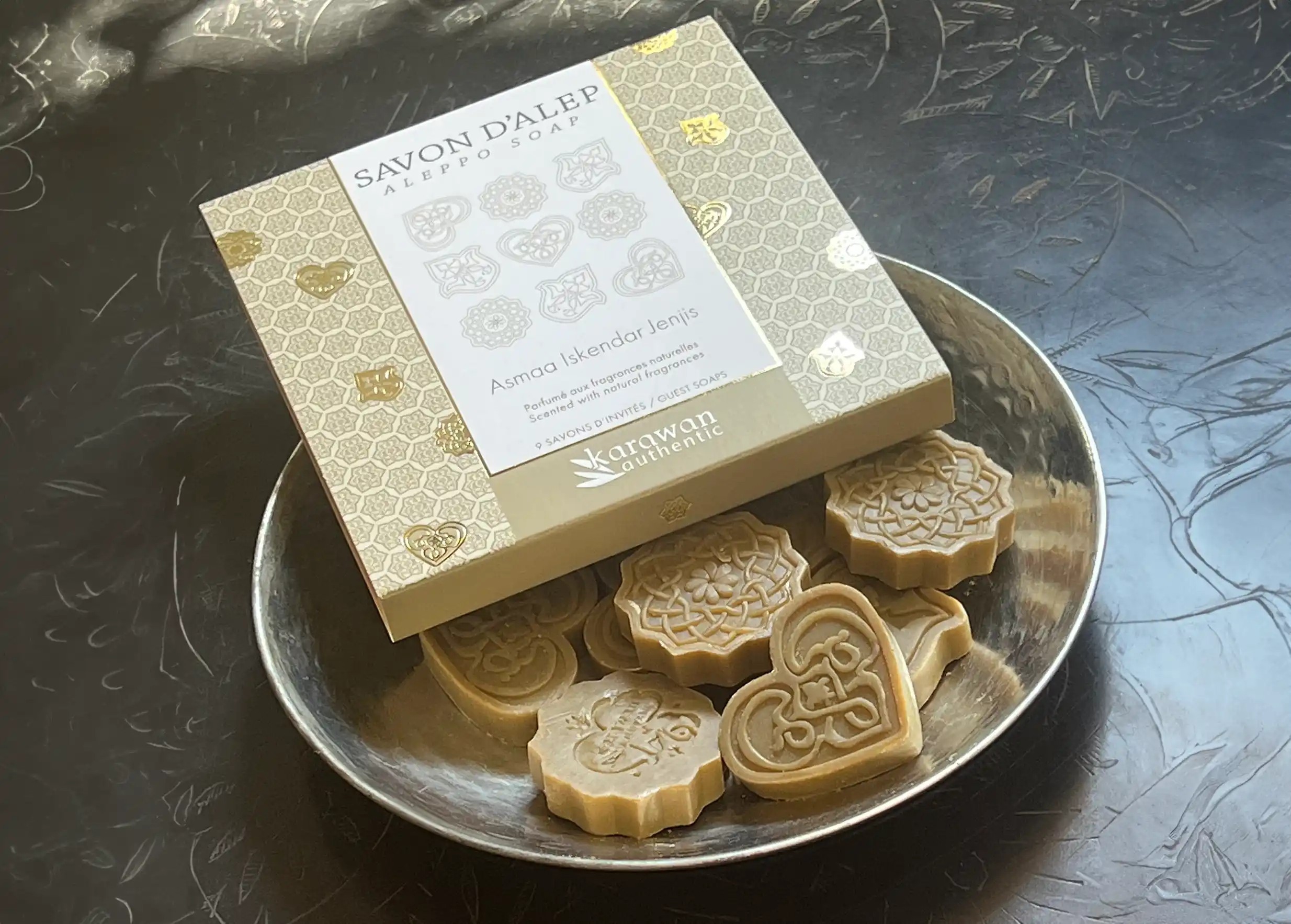 Assortiment de savons d'Alep d'invités parfumés de diverses formes, avec leur coffret dans un récipient en laiton