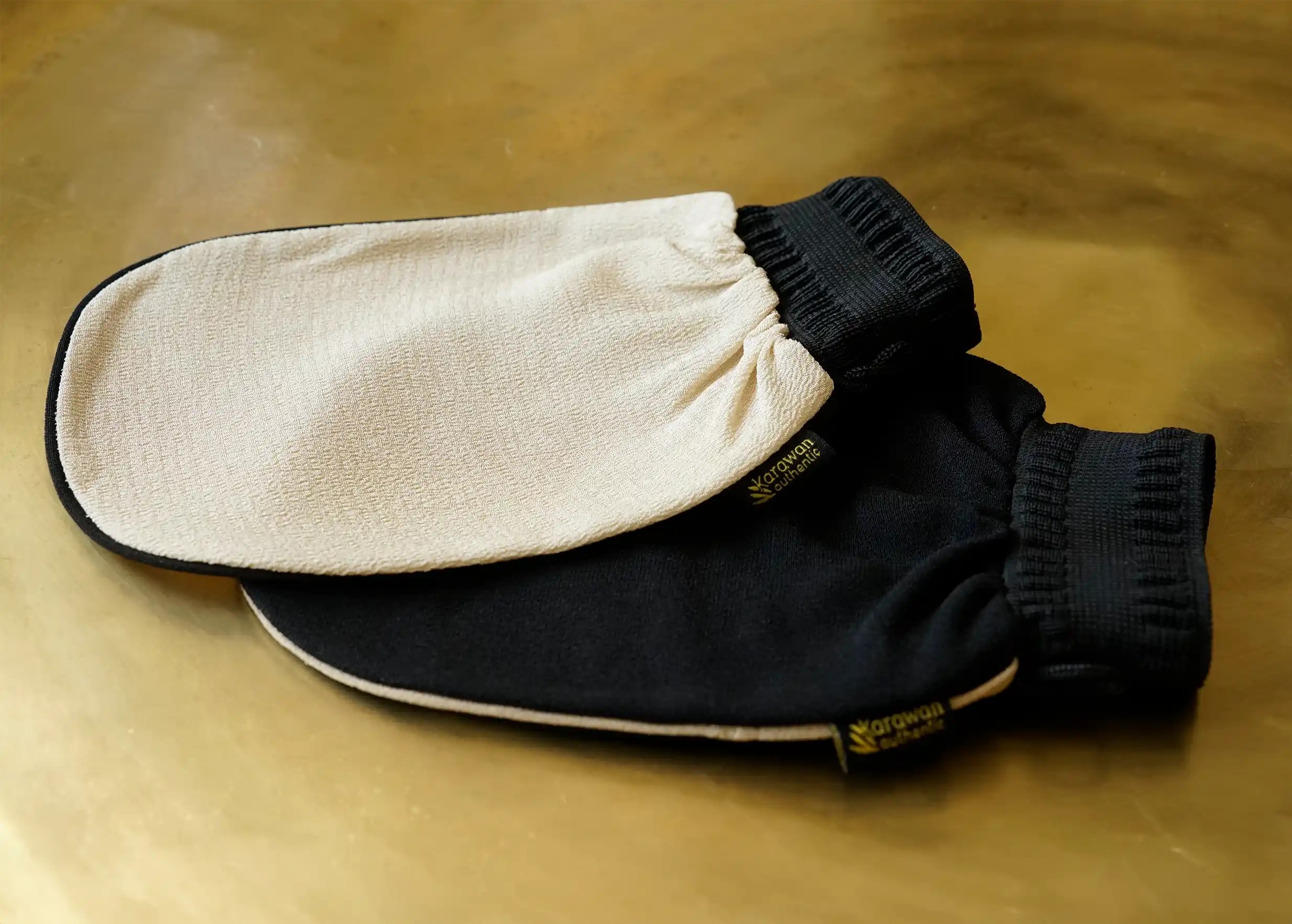Two kessa scrubbing gloves for the hammam, black and beige