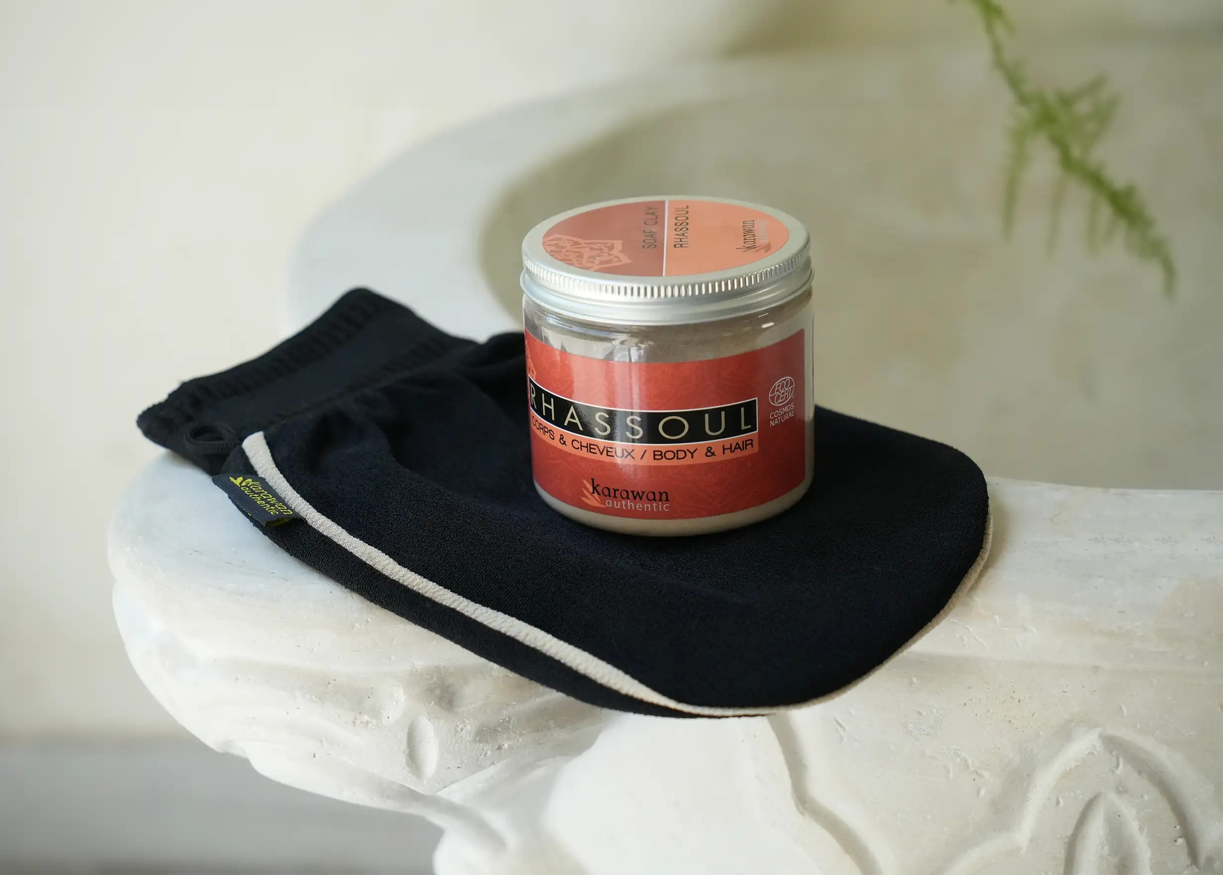 Rhassoul powder in a 200g jar, and black kessa glove with beige edging