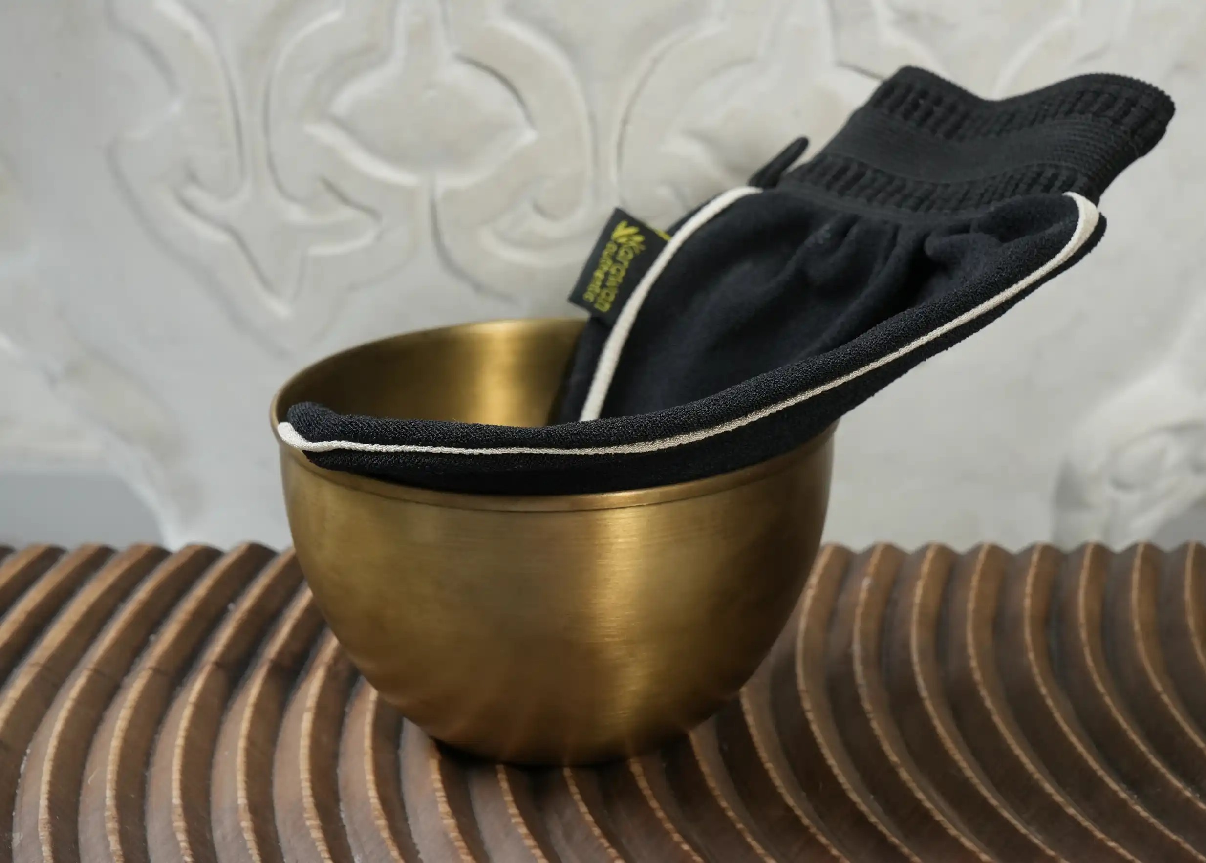 Medium-grain black kessa glove in a gilded brass bowl