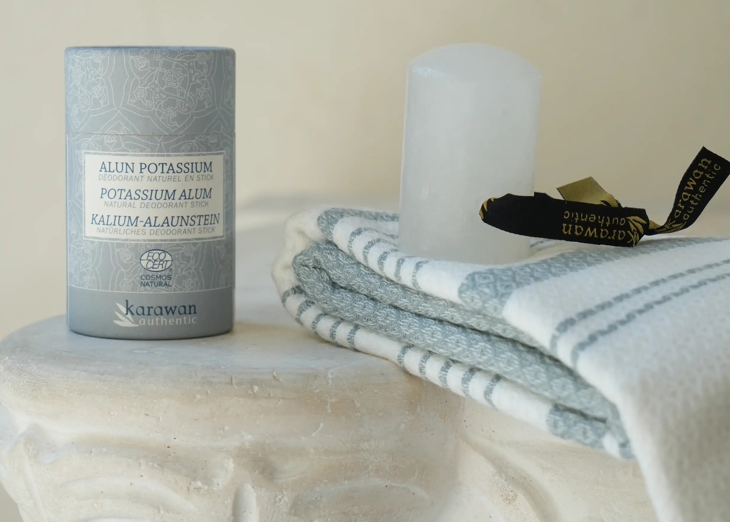 Alum stone stick with ribbon and protective case, accompanied by an organic cotton fouta