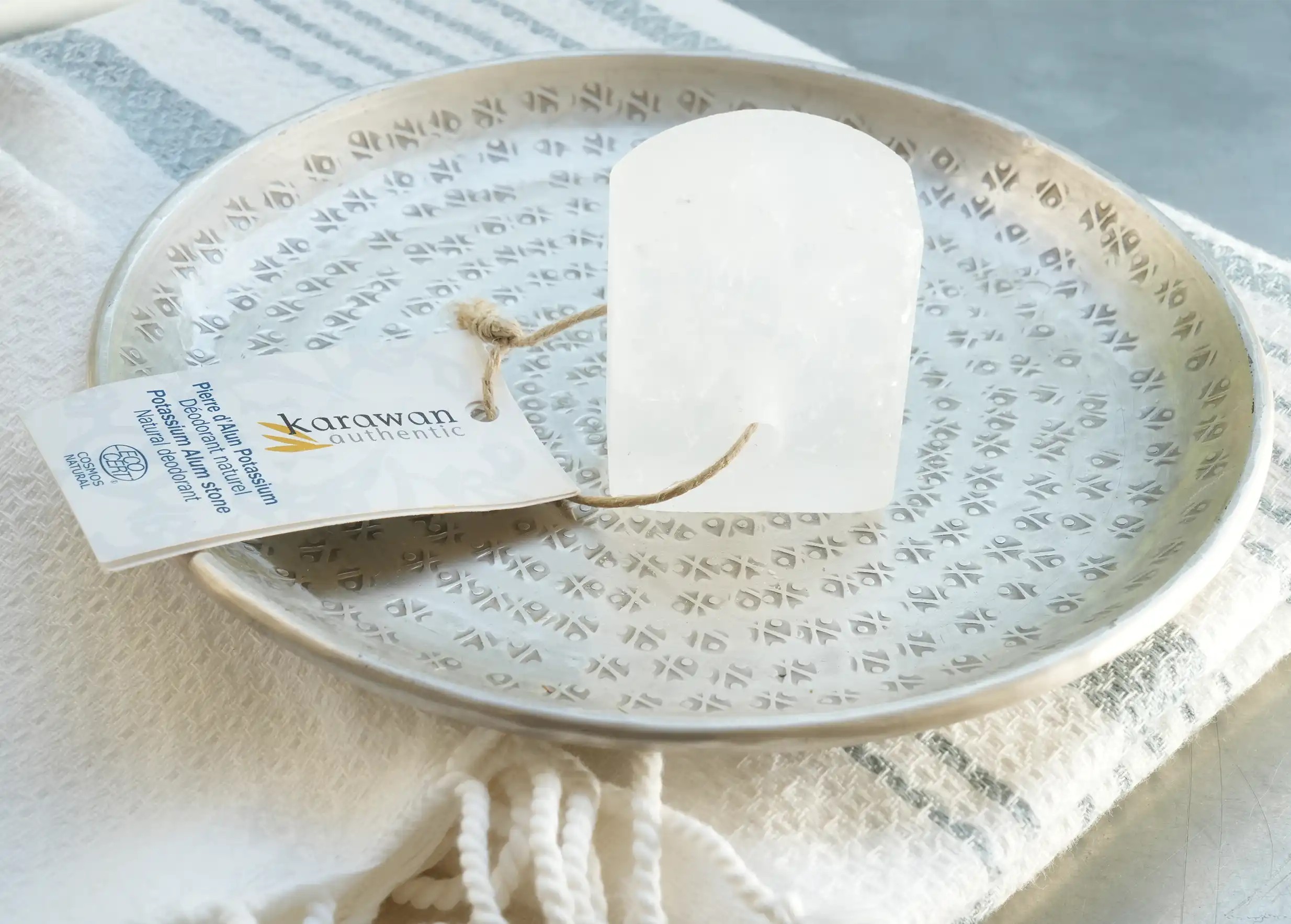 Natural deodorant with alum stone on an engraved and hammered brass dish