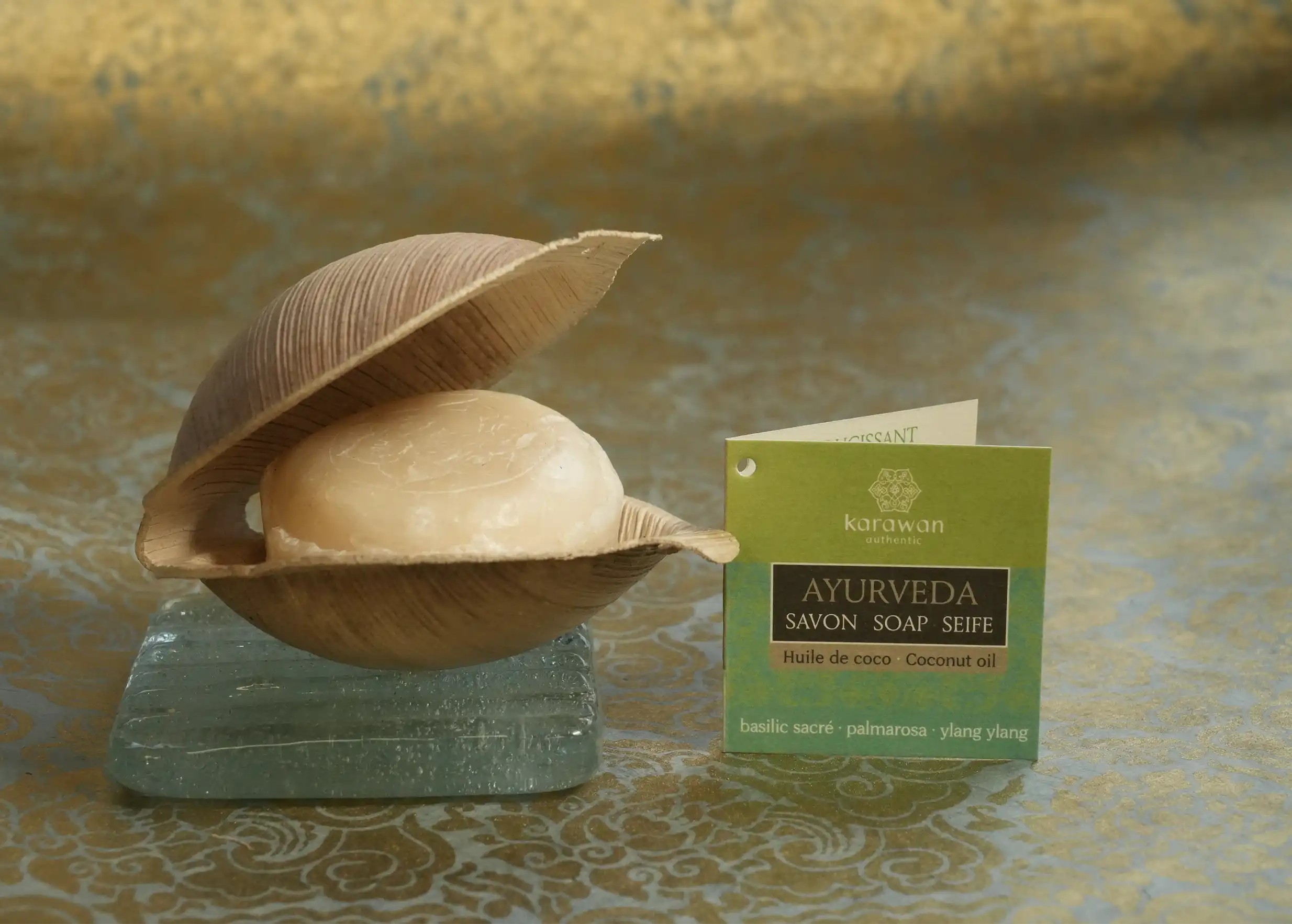 Savon ayurvédique basilic sacré à l'intérieur de sa coque ouverte, porte-savon en verre