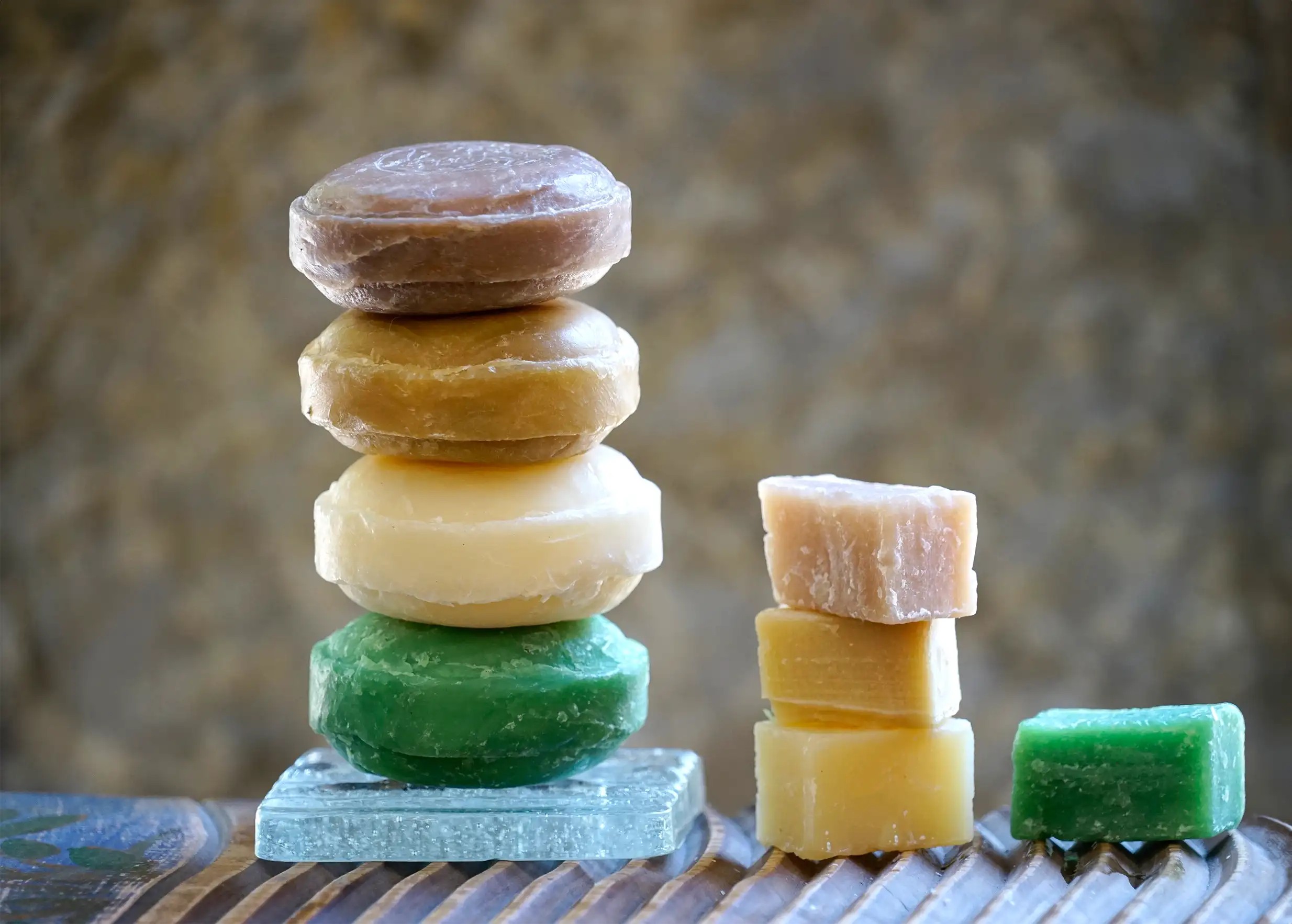 Pile de savons ayurvédiques ronds sur un porte savon, et mini savons ayurvédiques