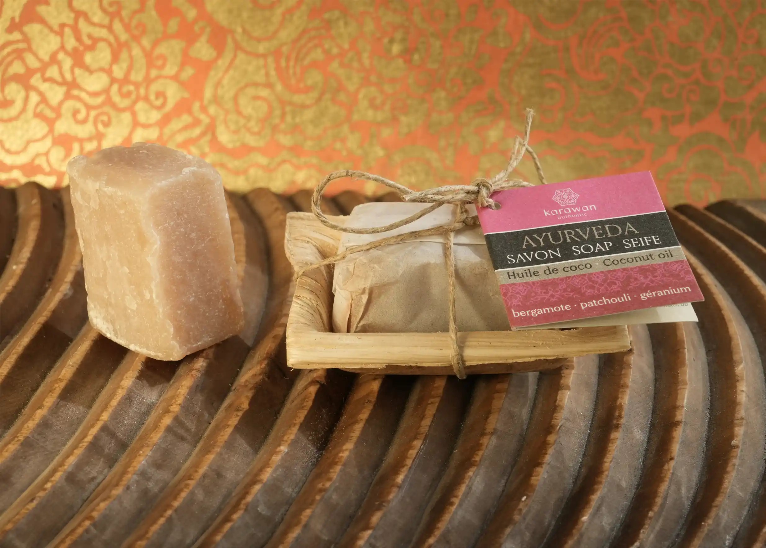 Mini Ayurvedic soaps with coconut oil, bergamot, patchouli and geranium, placed on a wooden surface.