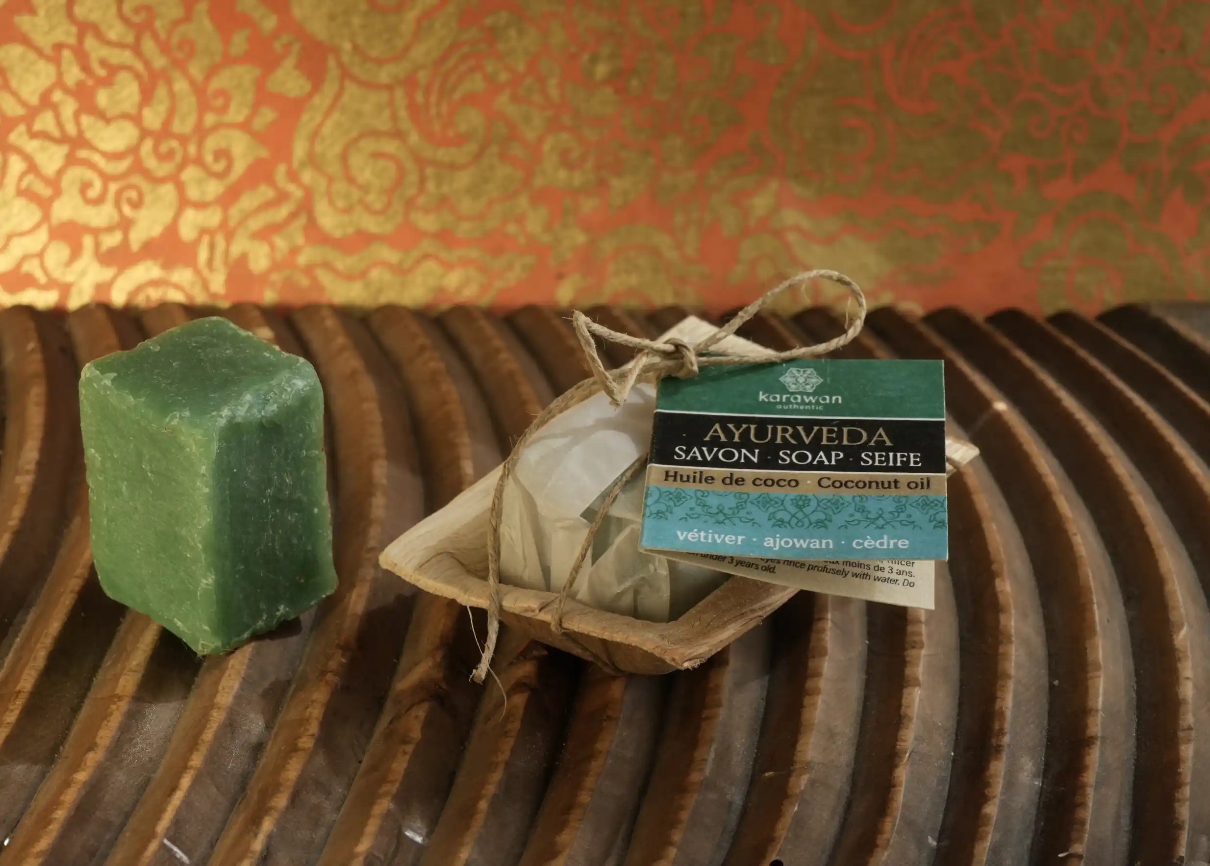 Mini Ayurvedic soaps with coconut oil, vetiver, ajowan and cedar, placed on a wooden surface