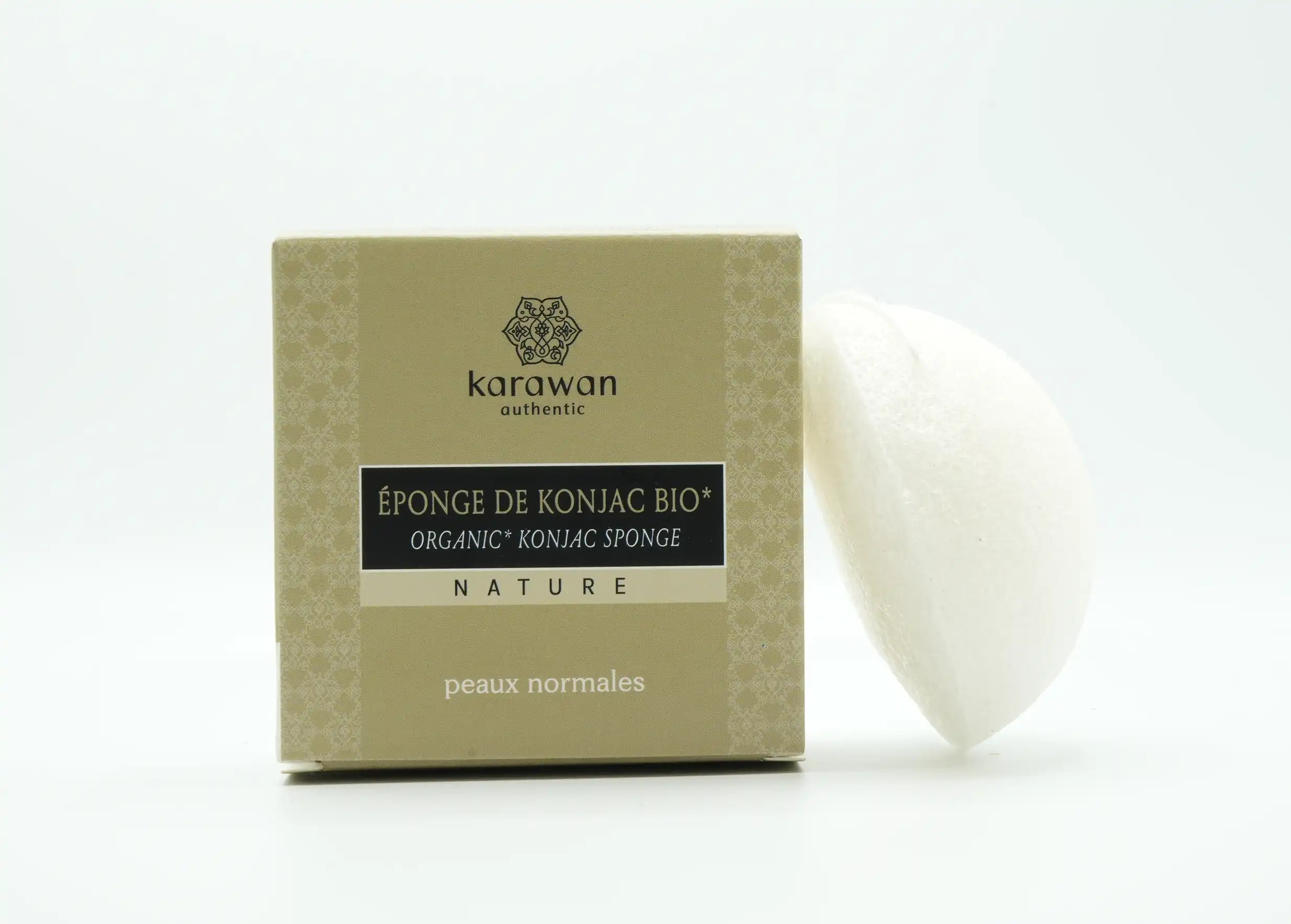 Éponge de konjac bio naturelle, de couleur blanche, posée contre un emballage en carton de la marque Karawan
