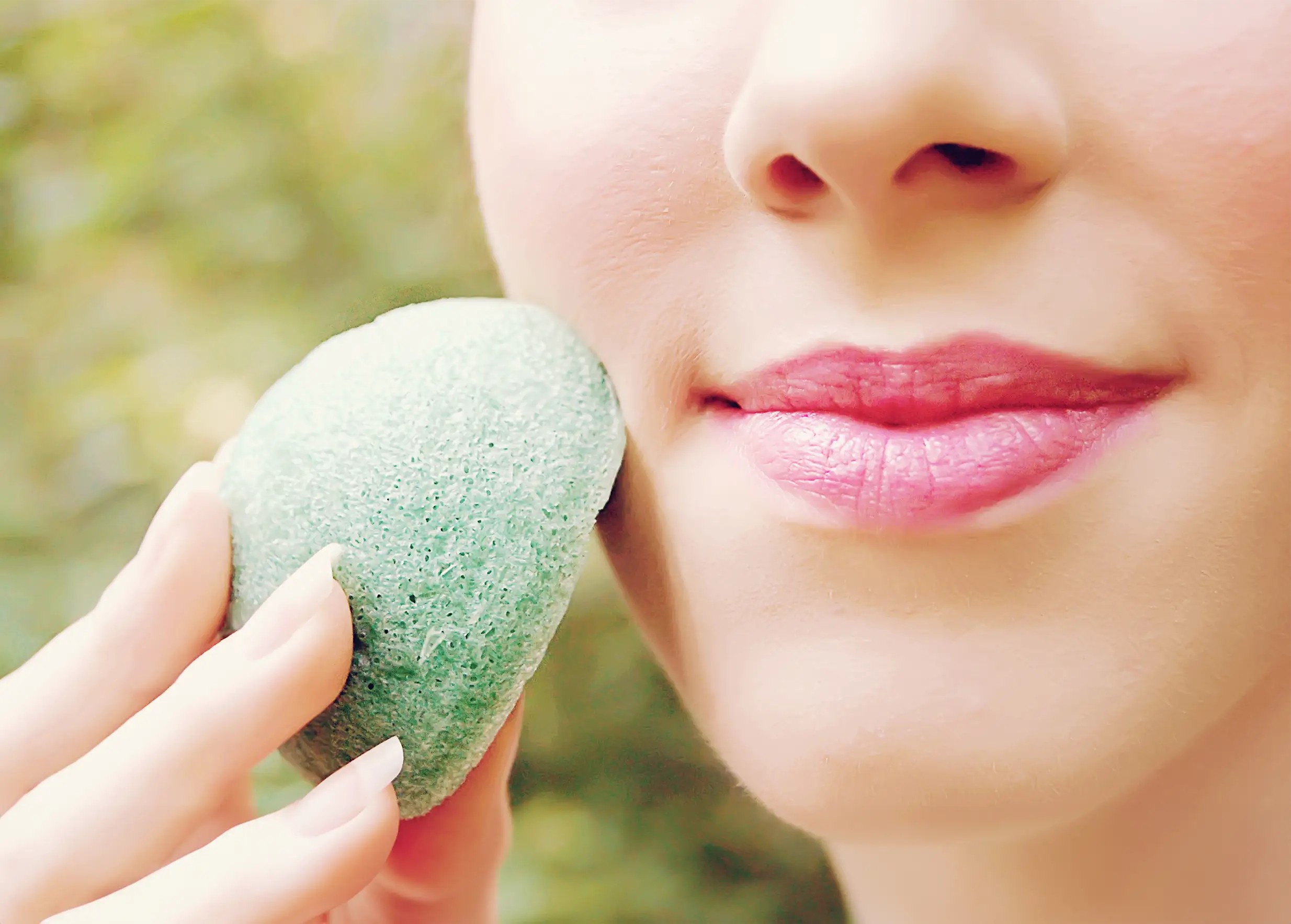 Femme appliquant une éponge de konjac bio enrichie à l'aloe vera sur sa joue