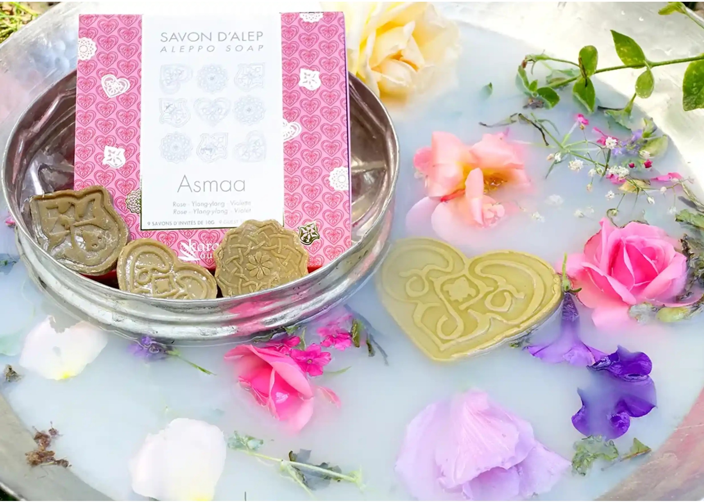 Savons d'Alep d'invités Karawan aux fragrances naturelles, entourés de fleurs et de plantes