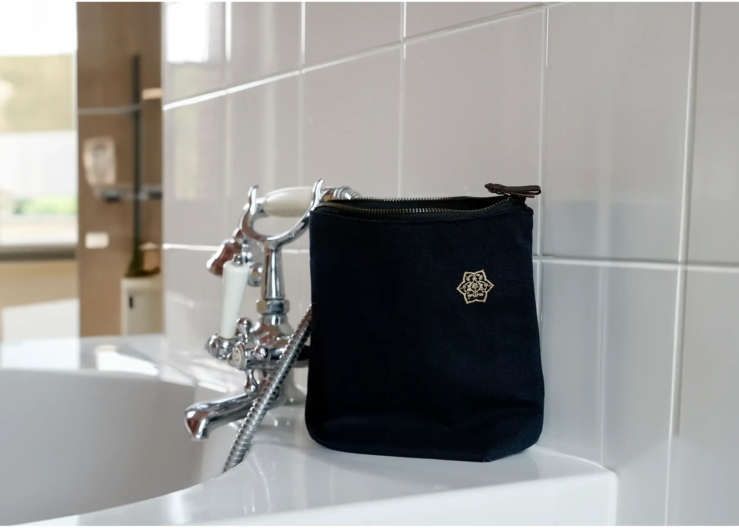 Shade cotton canvas toilet bag in indigo on the edge of a bathroom bathtub