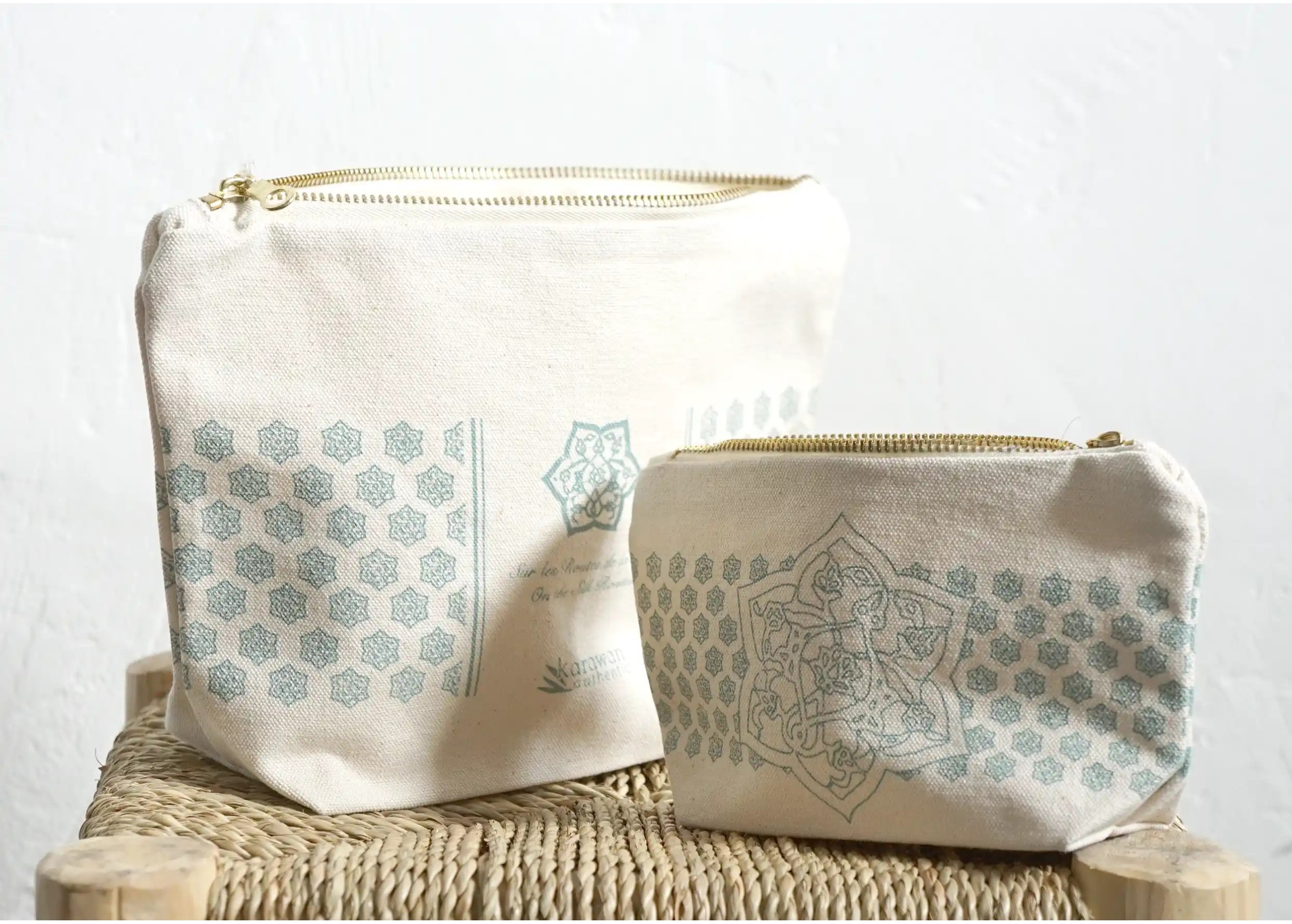 White cotton toiletry bags, one small bag and one large bag, placed on a stool
