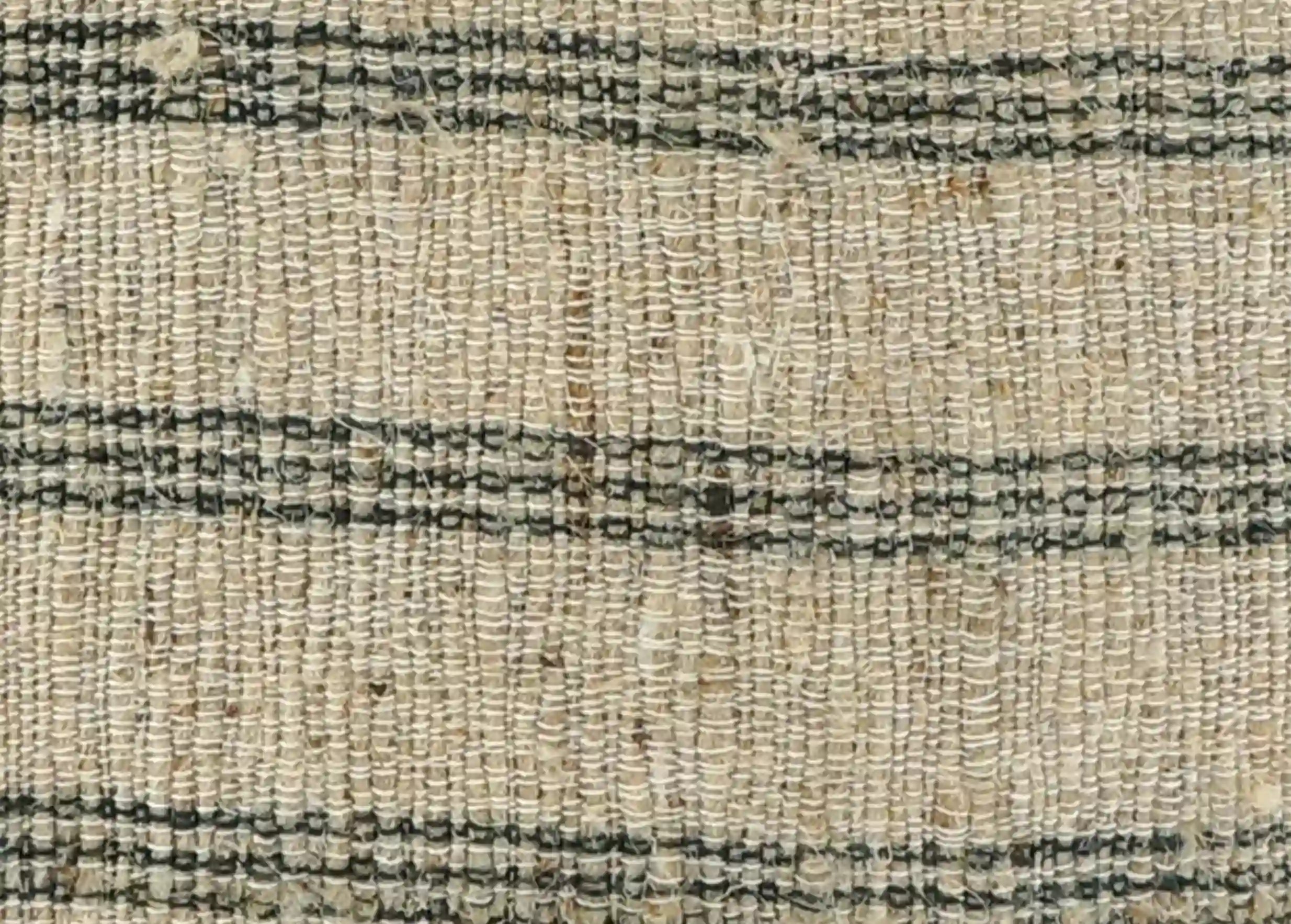 Close-up of handwoven fabric made from nettle and hemp, featuring black stripes