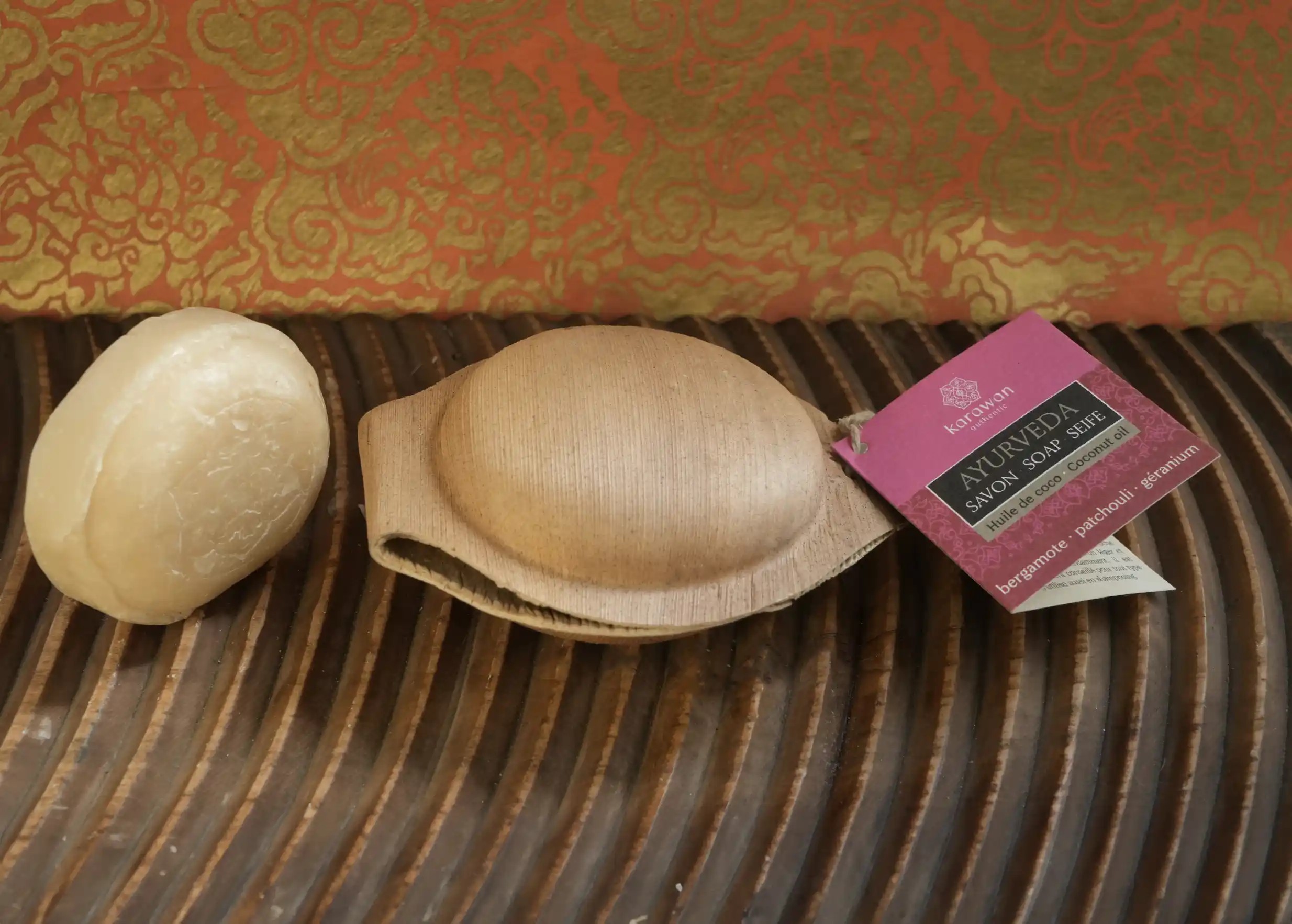 Solid round bergamot soap, palm leaf shell and Karawan label, textured surface
