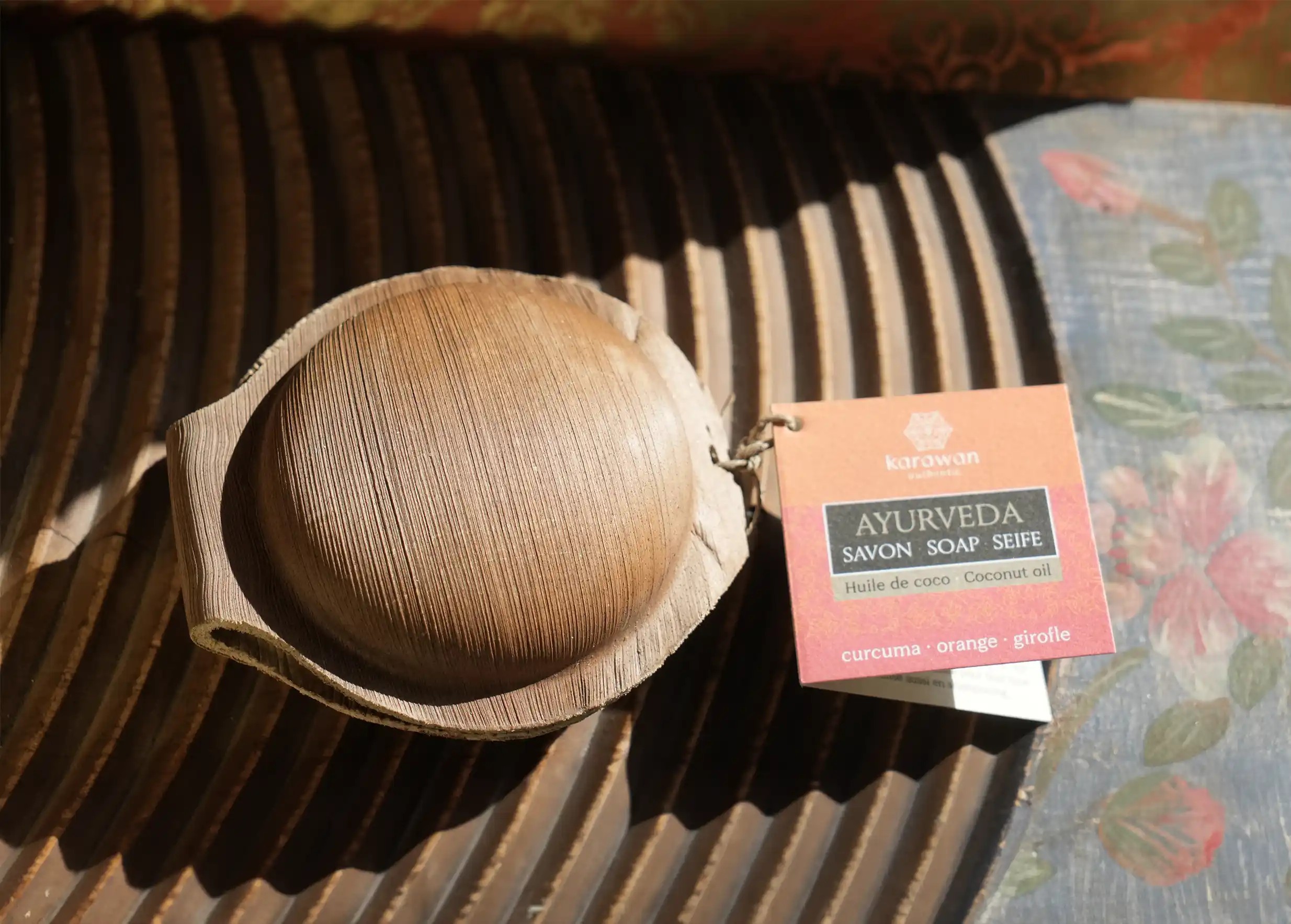 Turmeric soap in a palm leaf shell, cardboard label with fragrance list