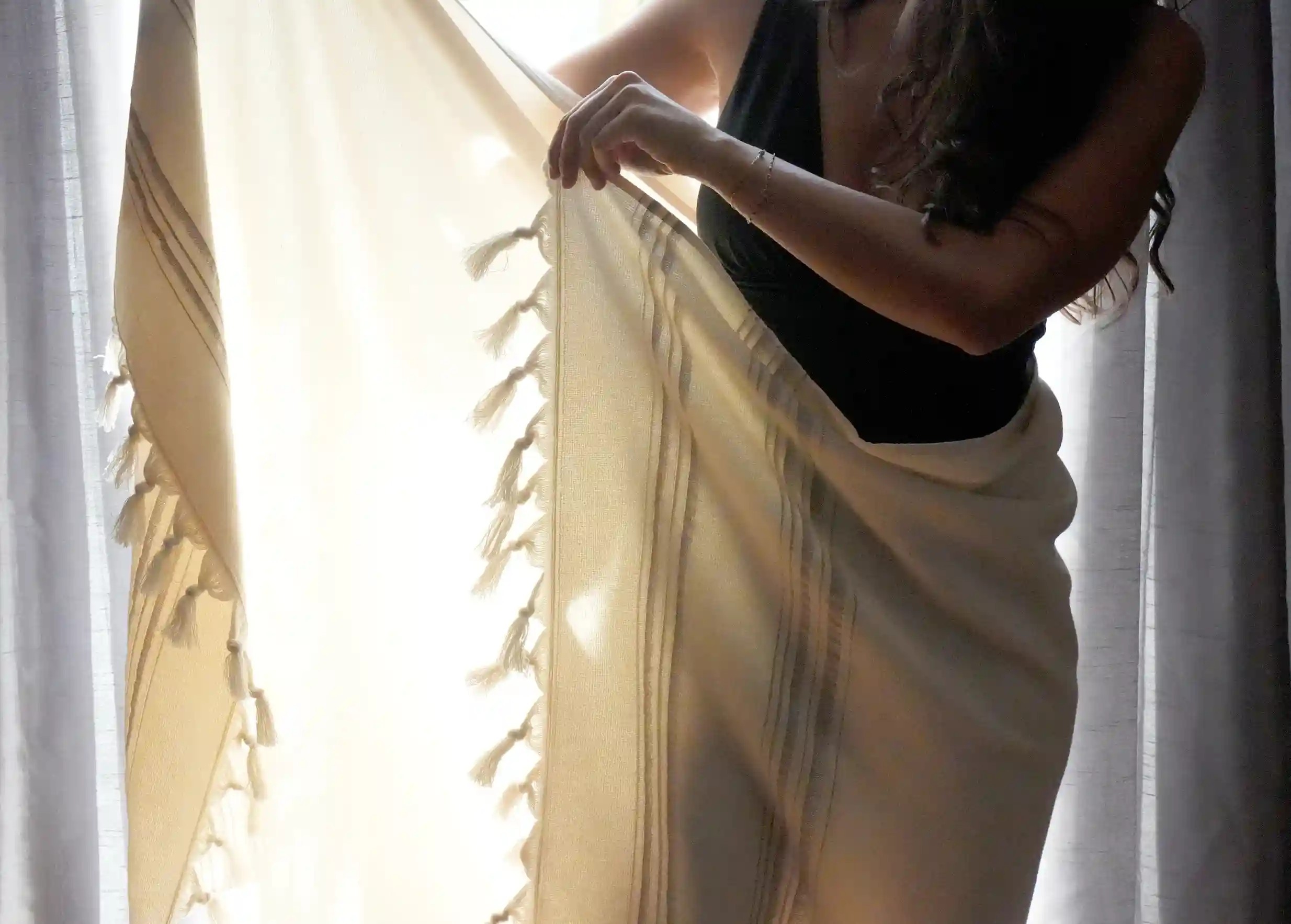 Dolce Fouta portée autour de la taille par une femme, lumière se reflétant à travers le textile