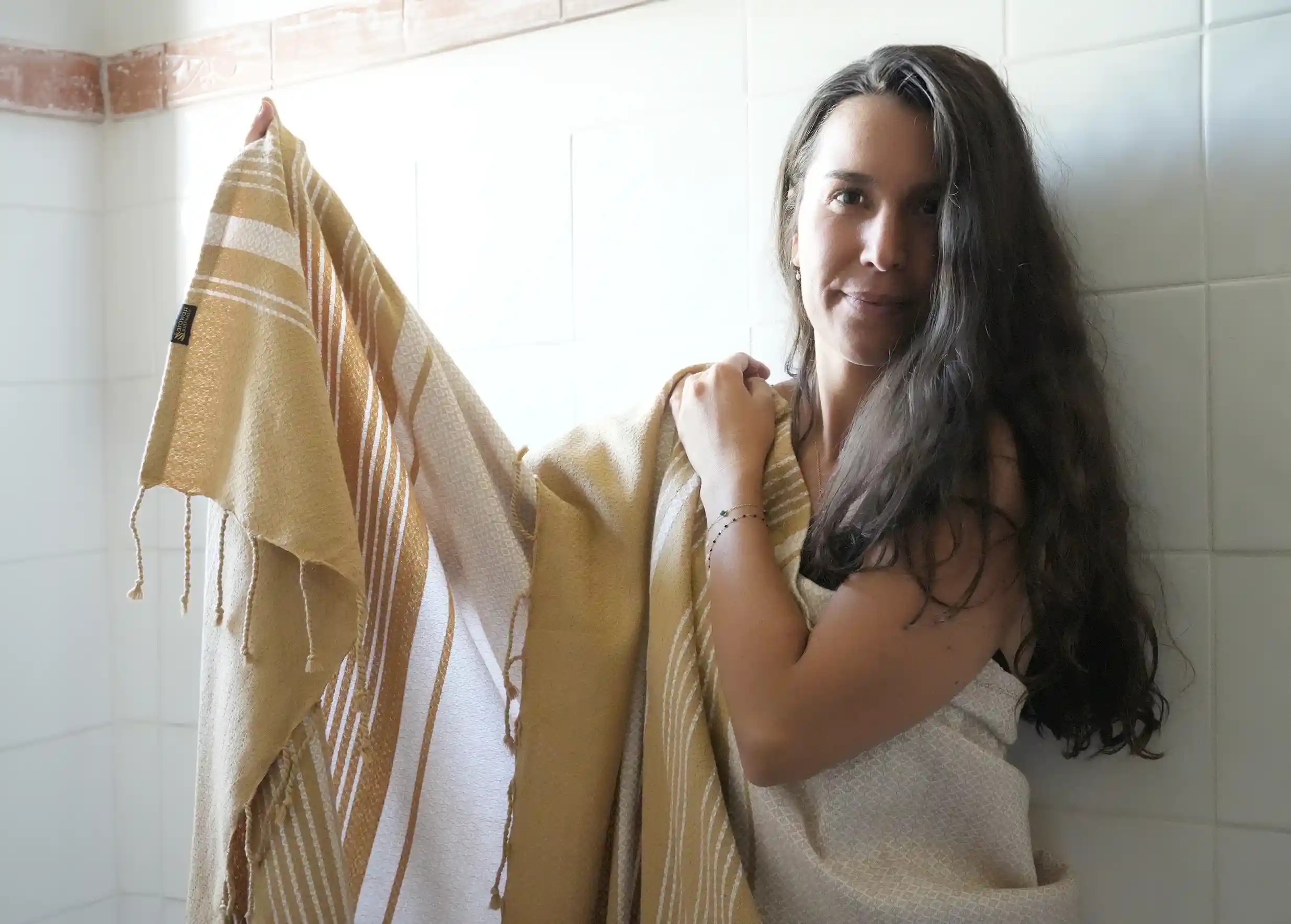 Femme enveloppée dans une fouta en coton biologique coloris blanc pur, tissé à la main à partir de coton biologique GOTS