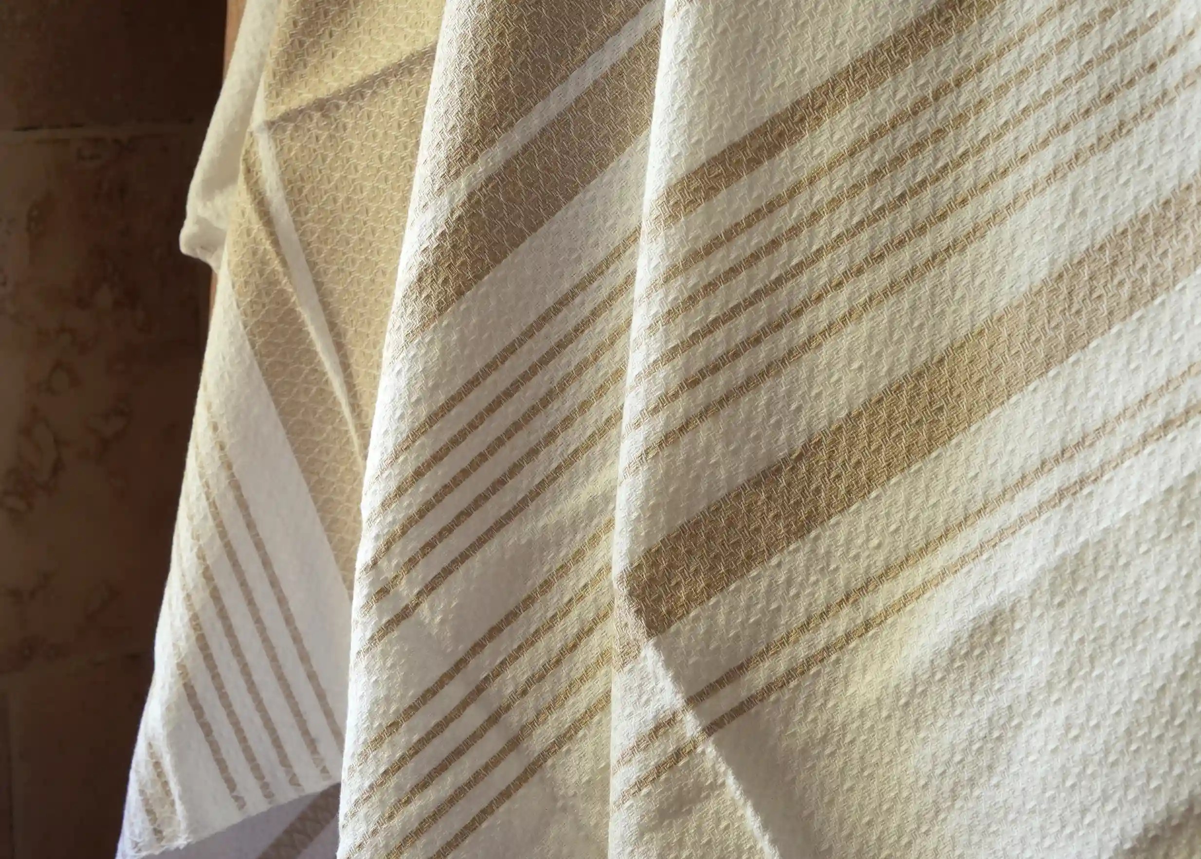Spotlight on the hand-woven foutas in organic White Sand cotton, with an exclusive design by Karawan