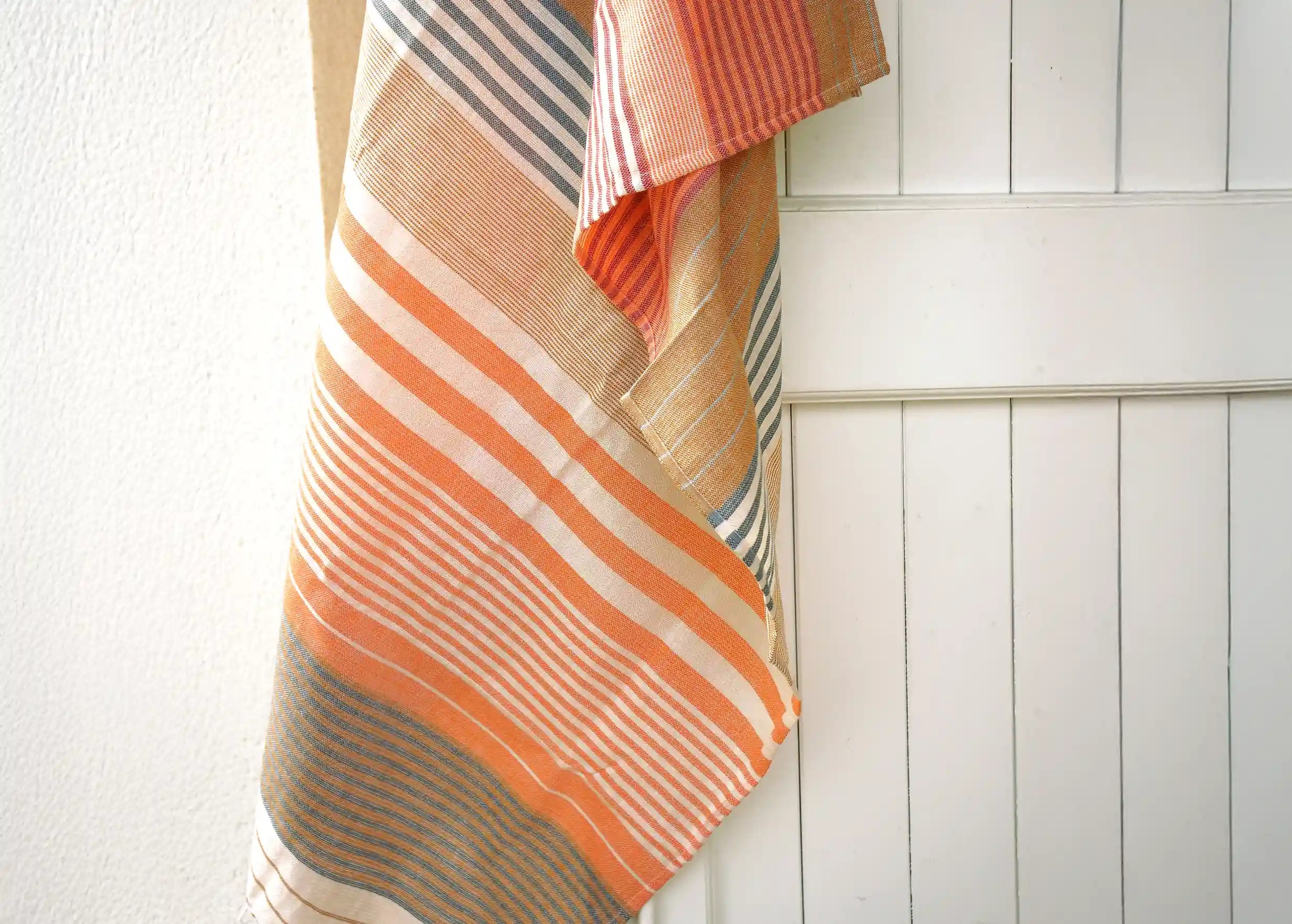 India Gold organic cotton fouta from the Sud collection against a wall
