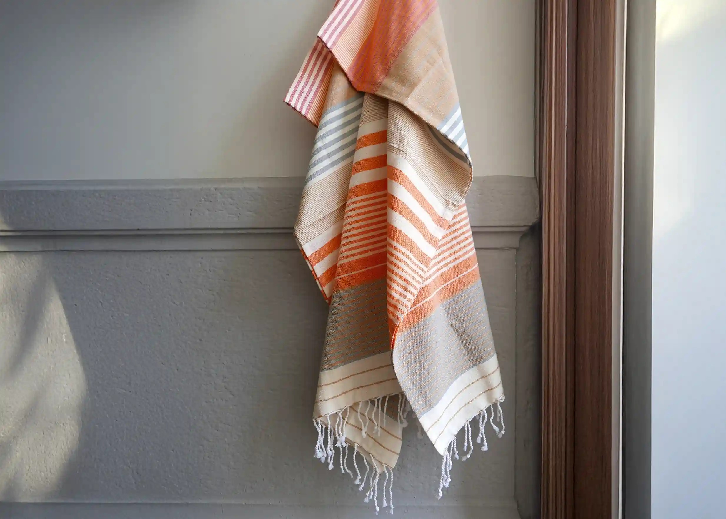 Fouta coloris India gold de la collection Sud en coton bio accrochée contre le mur