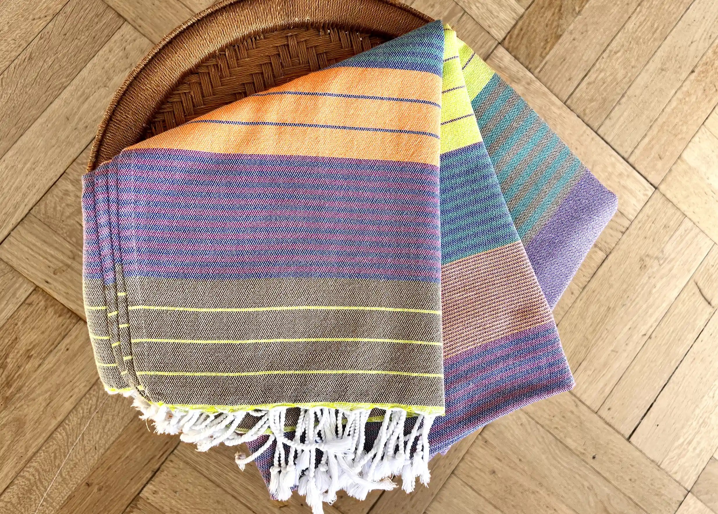 Purple sun coloured fouta in cotton by Karawan, folded on a stool