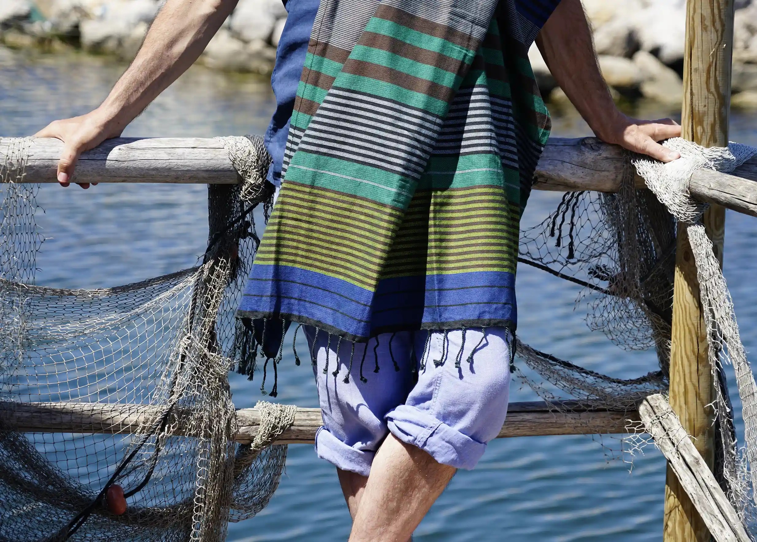 Homme portant la fouta en coton bio coloris Forest, des dominantes de bleu et de vert