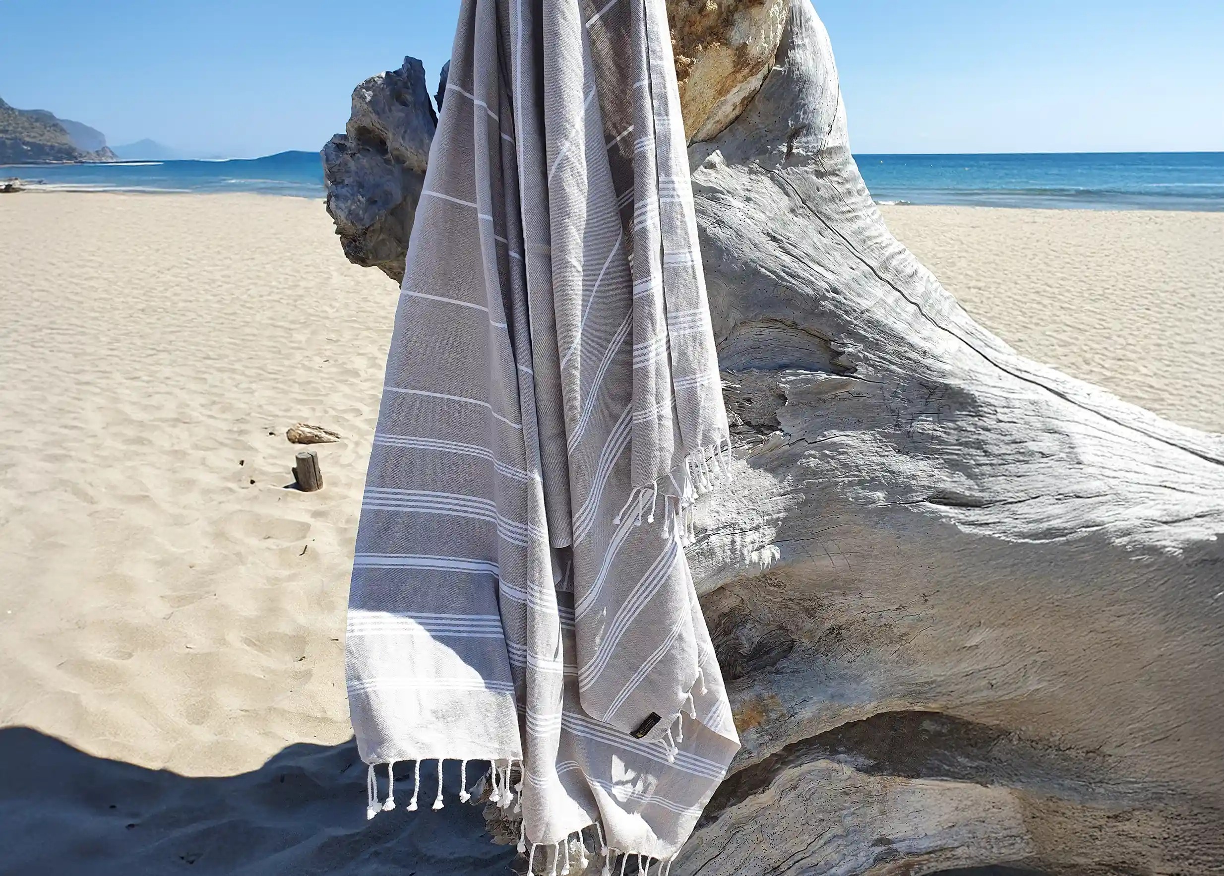 Fouta en coton bio coloris taupe suspendue à une branche d'arbre Fouta en coton bio coloris taupe suspendue à une branche d'arbre