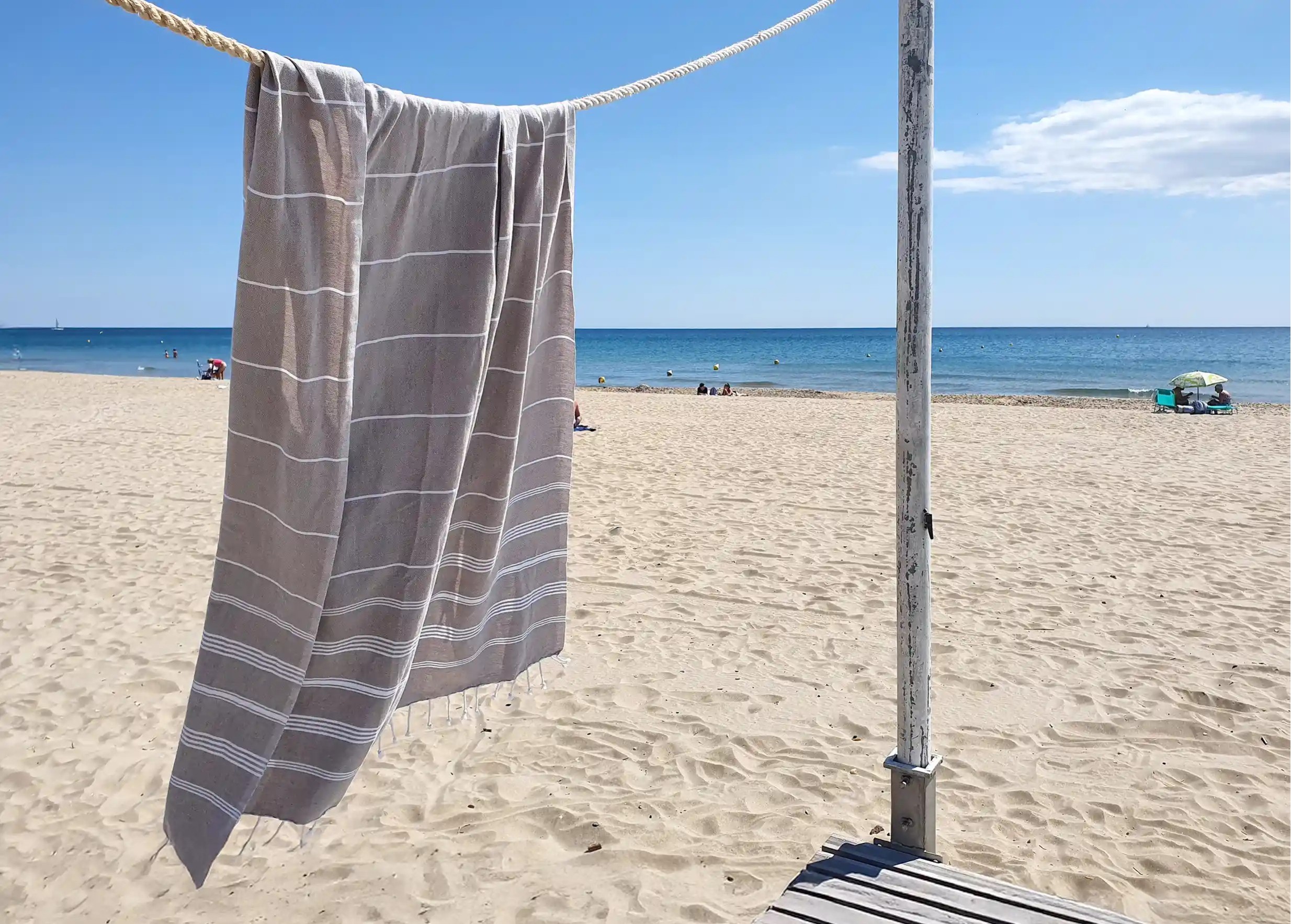 Taupe light grey coloured Hammam Fouta, on a clothesline with a beachy feel Taupe light grey coloured Hammam Fouta, on a clothesline with a beachy feel