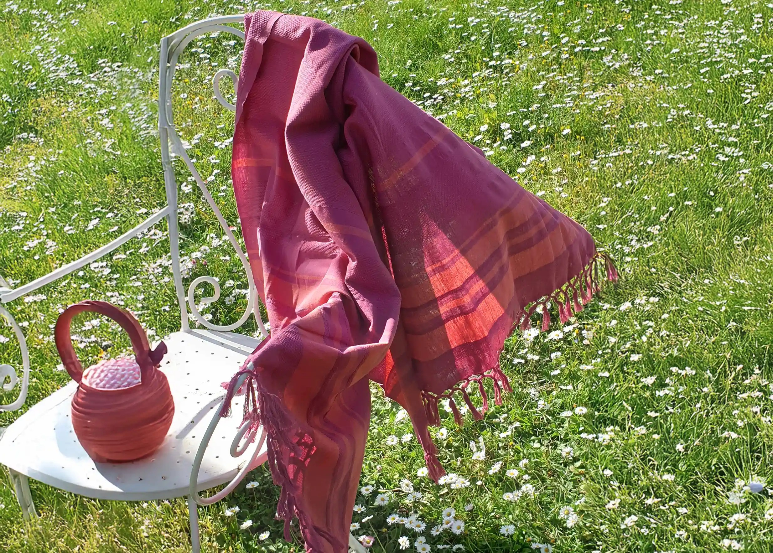 Fouta en coton bio Fushia de la collection Garden, posée sur une chaise