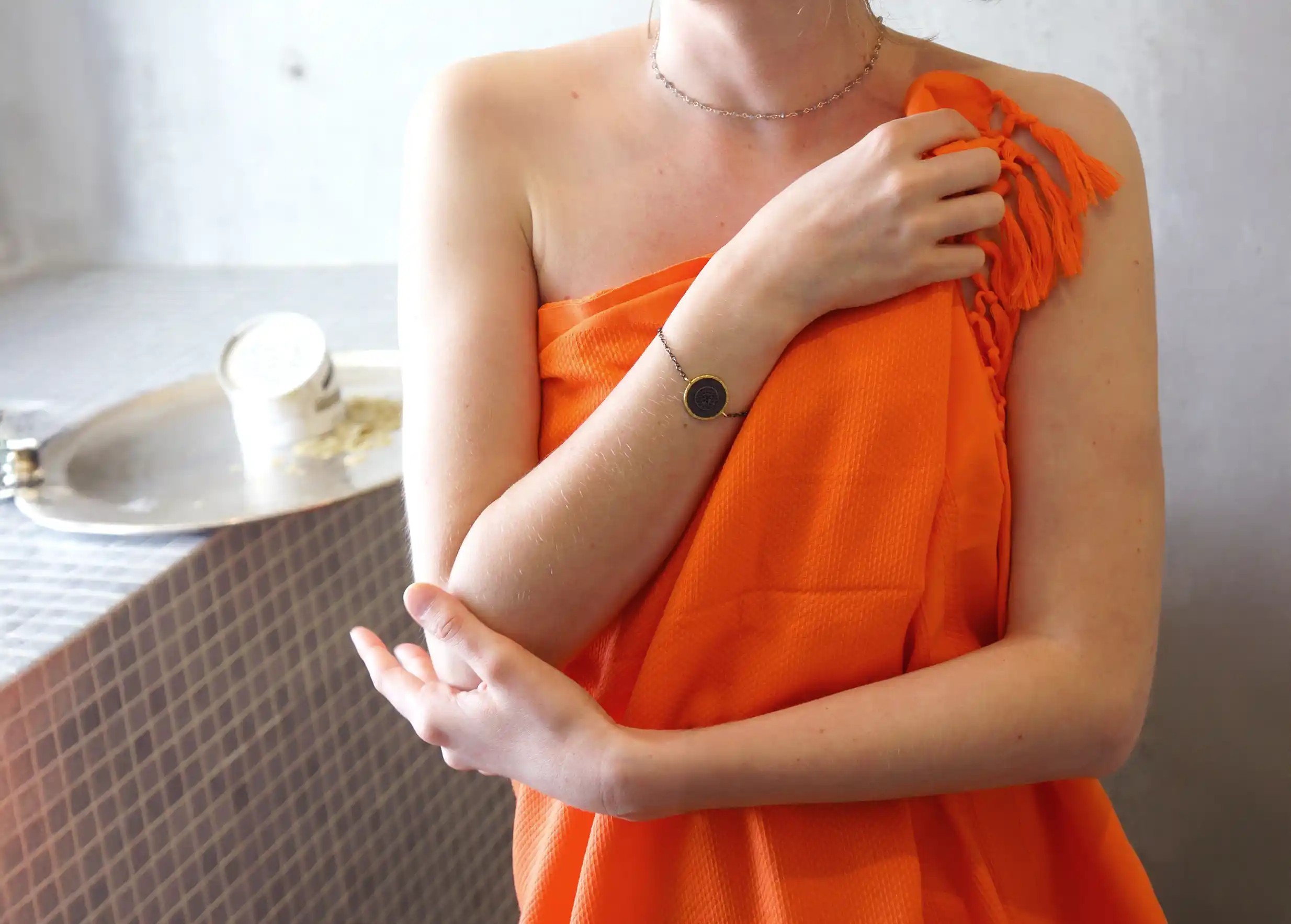 Fouta orange, coloris curcuma, portée par une femme autour de taille