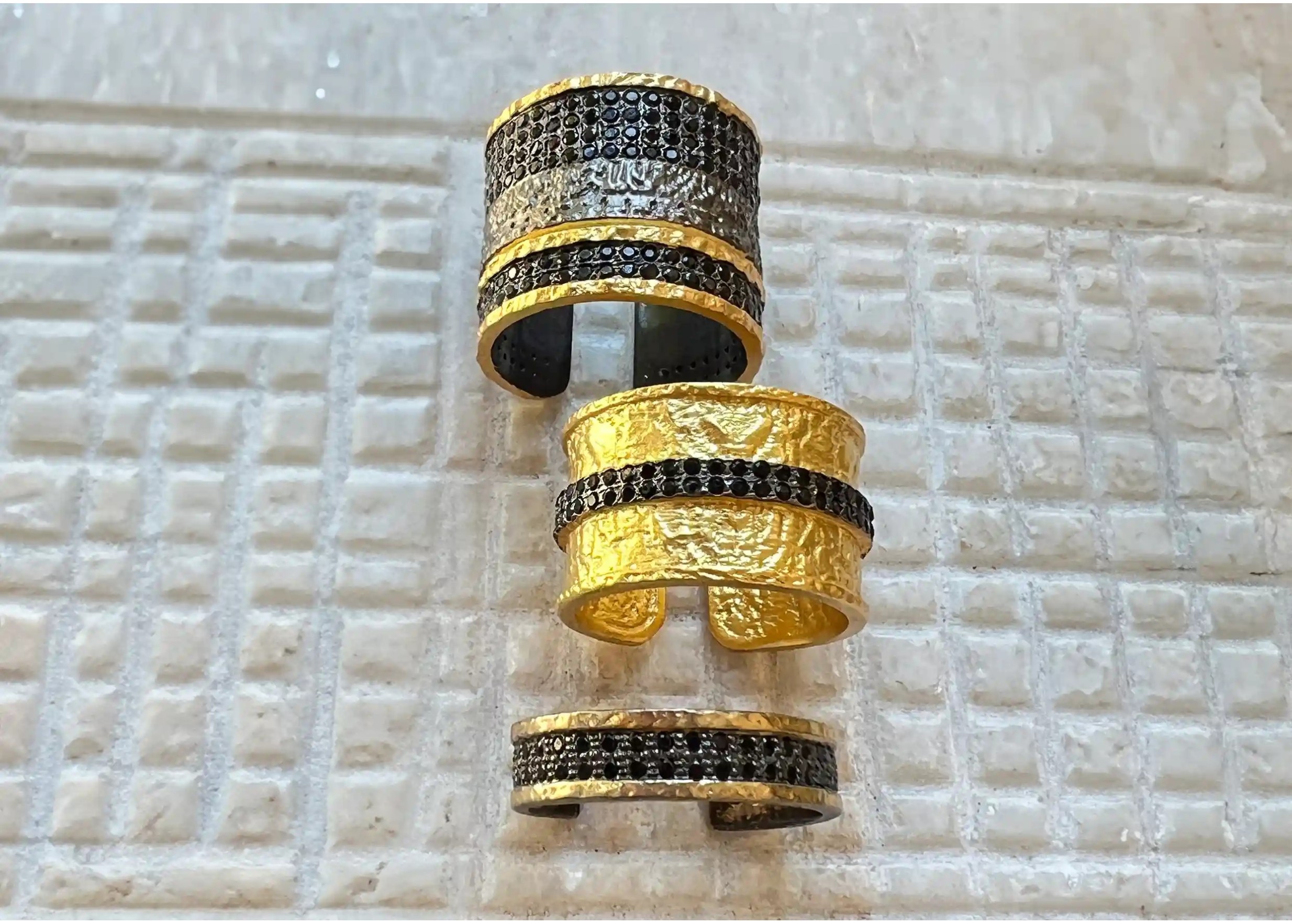 Set of gold-effect brass rings with a black zirconium band, from the Dawn of Time collection by Karawan