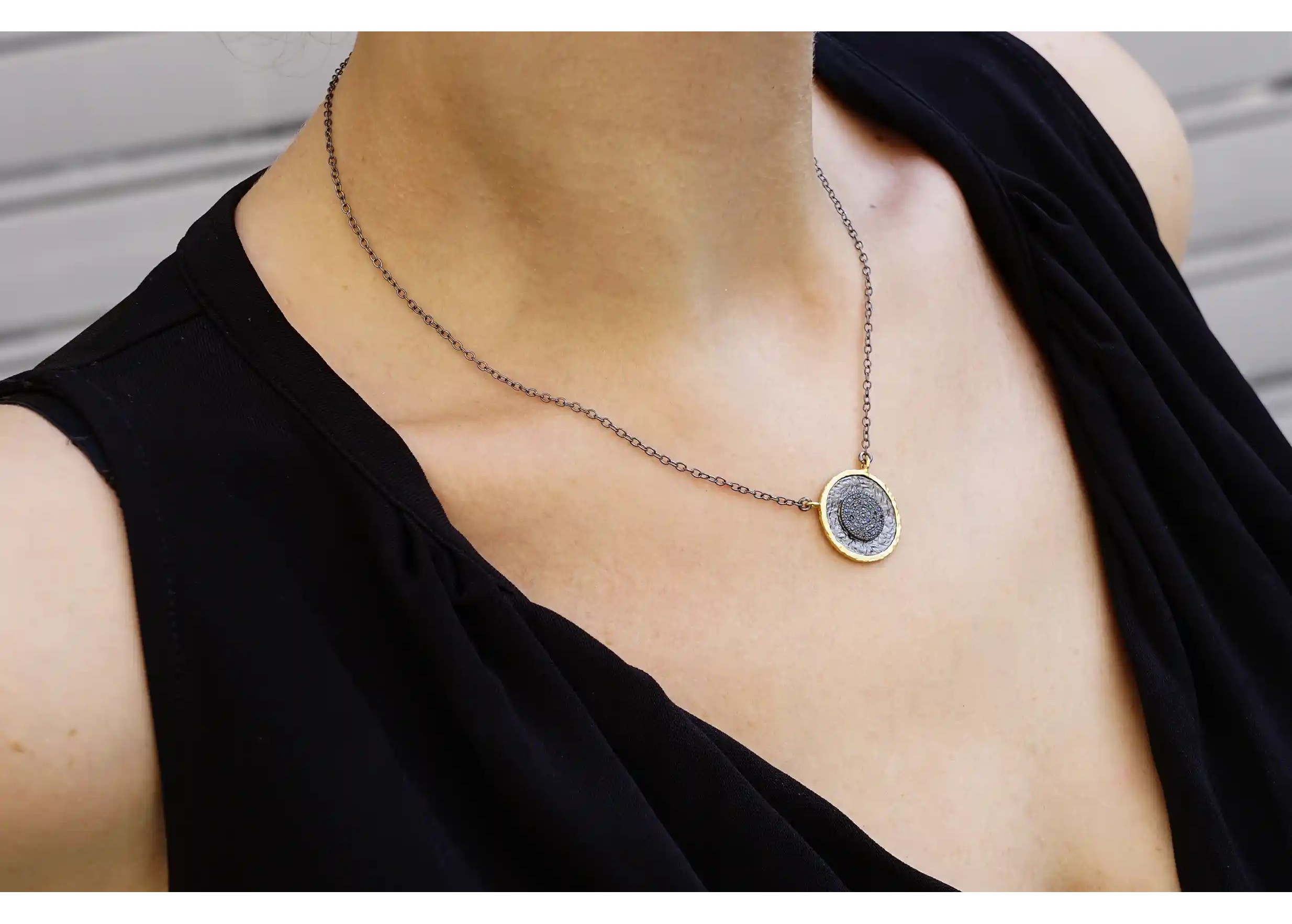Woman wearing a gilded-plated brass pendant from the Dawn of Time collection by Karawan