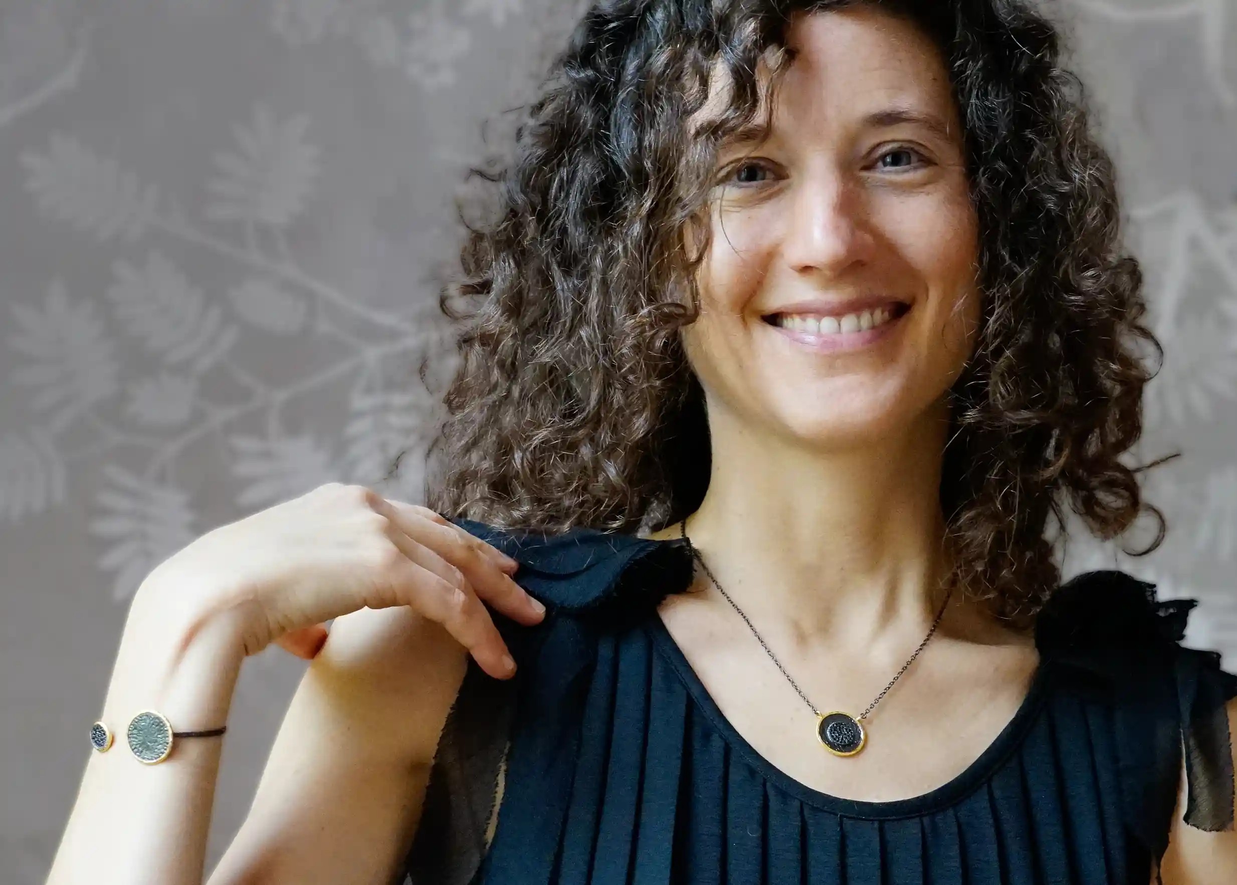 Gilded-plated brass pendant from the Dawn of Time collection worn with a matching bracelet