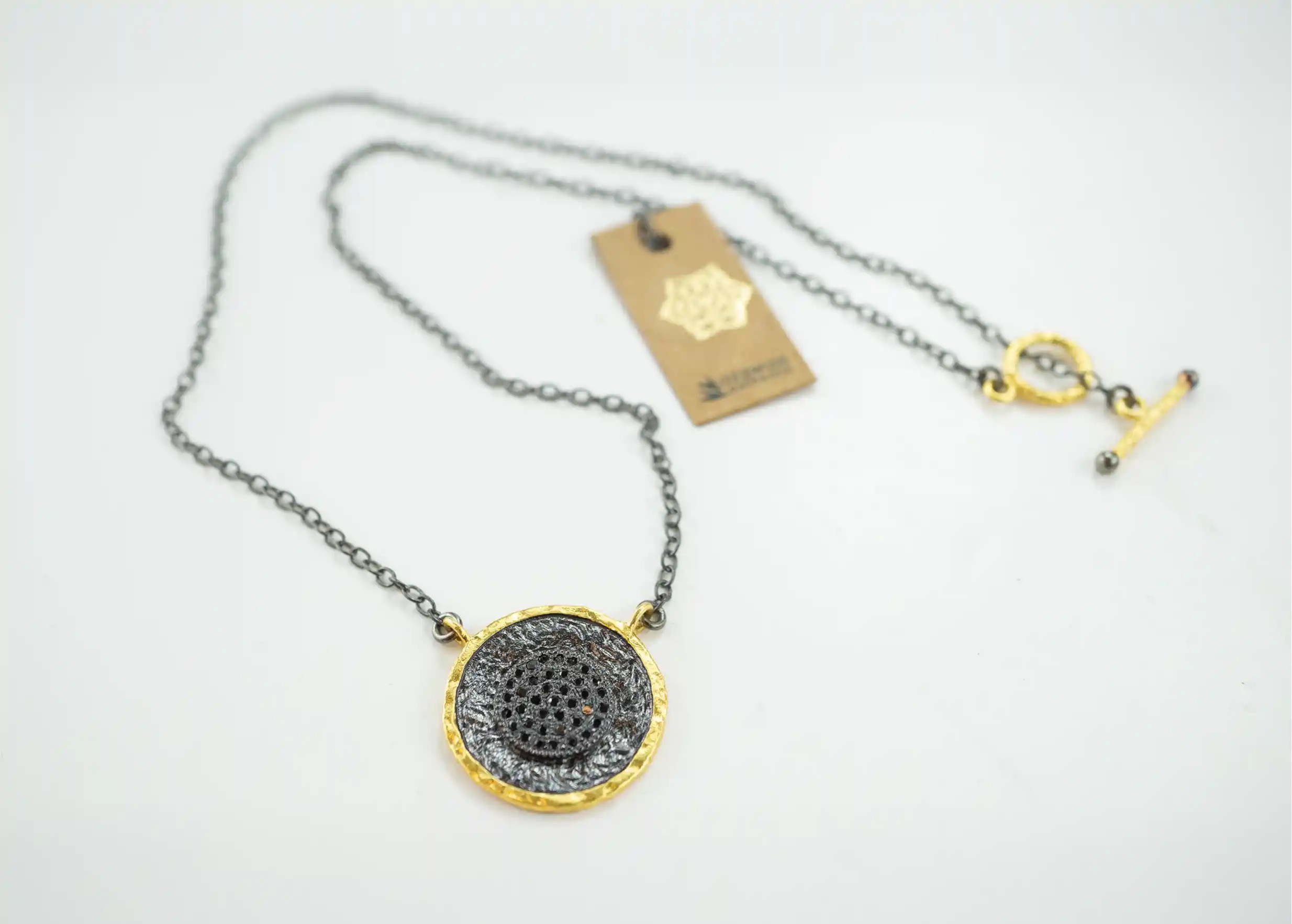 Pendentif laiton et zirconium de la collection Nuit des Temps avec étiquette Karawan authentic et fermeture en T