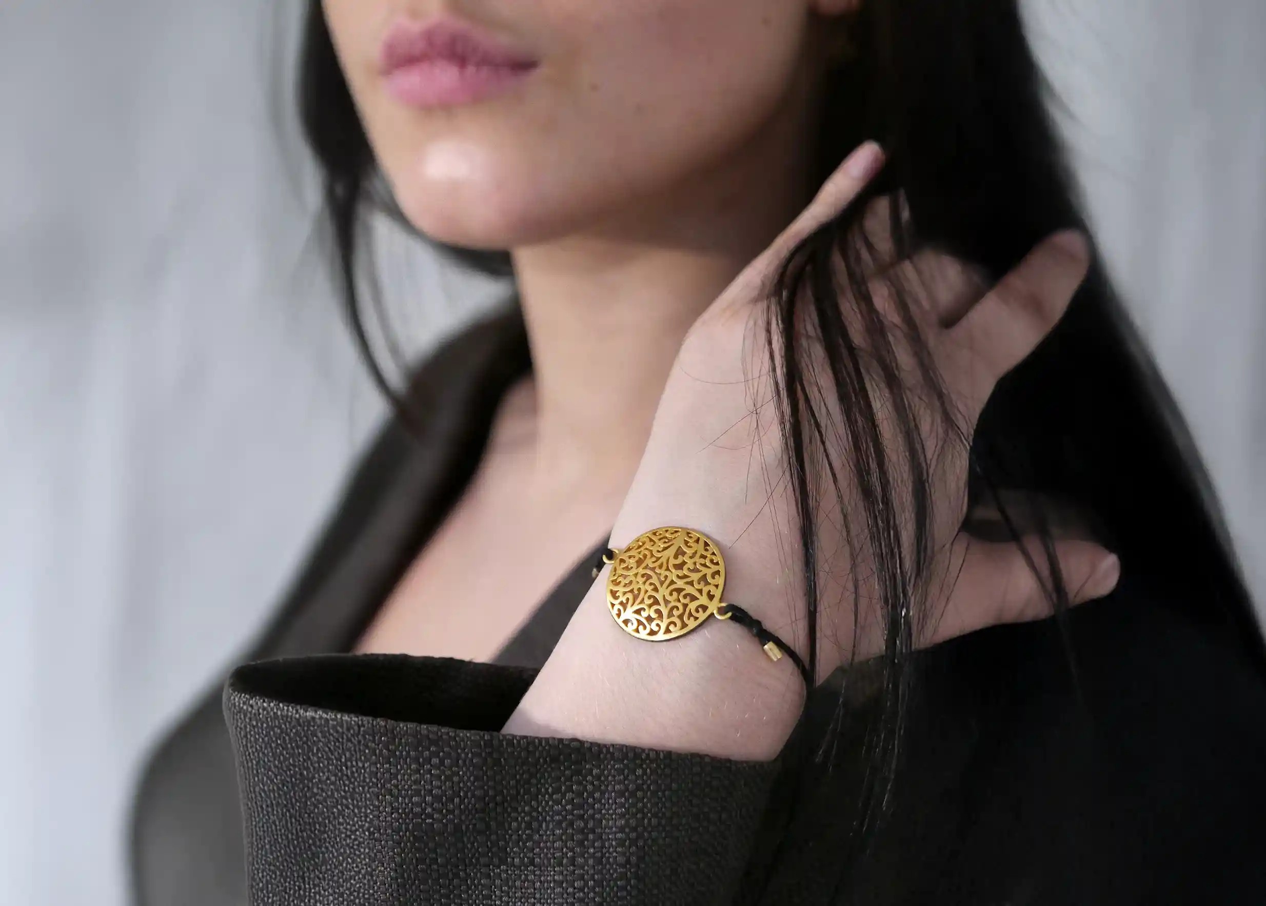 Gilded-plated brass bracelet from the Secret Garden jewellery worn by a woman around her wrist