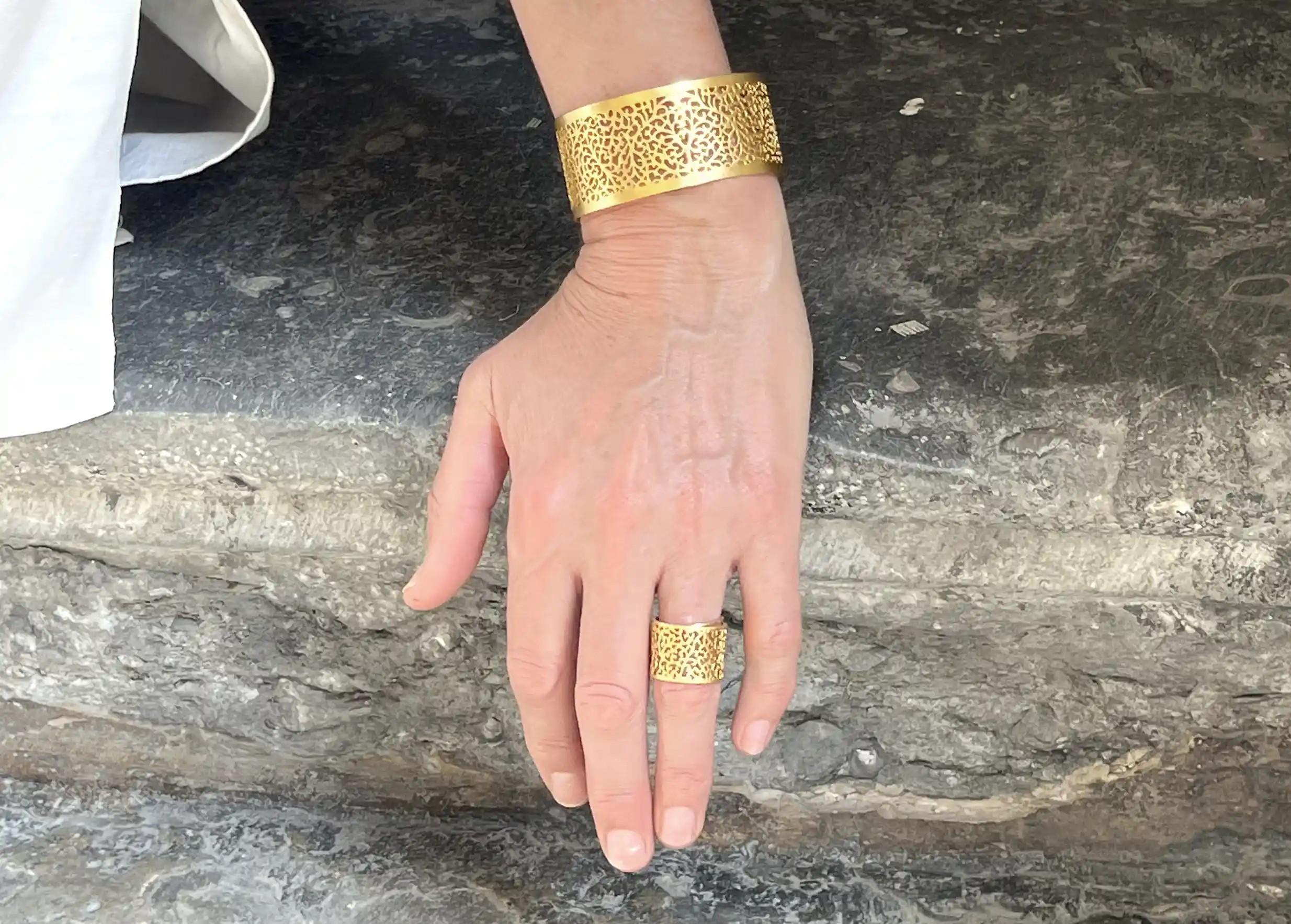 Manchette en laiton couleur or de la collection Jardin Secret portée par une femme au poignet