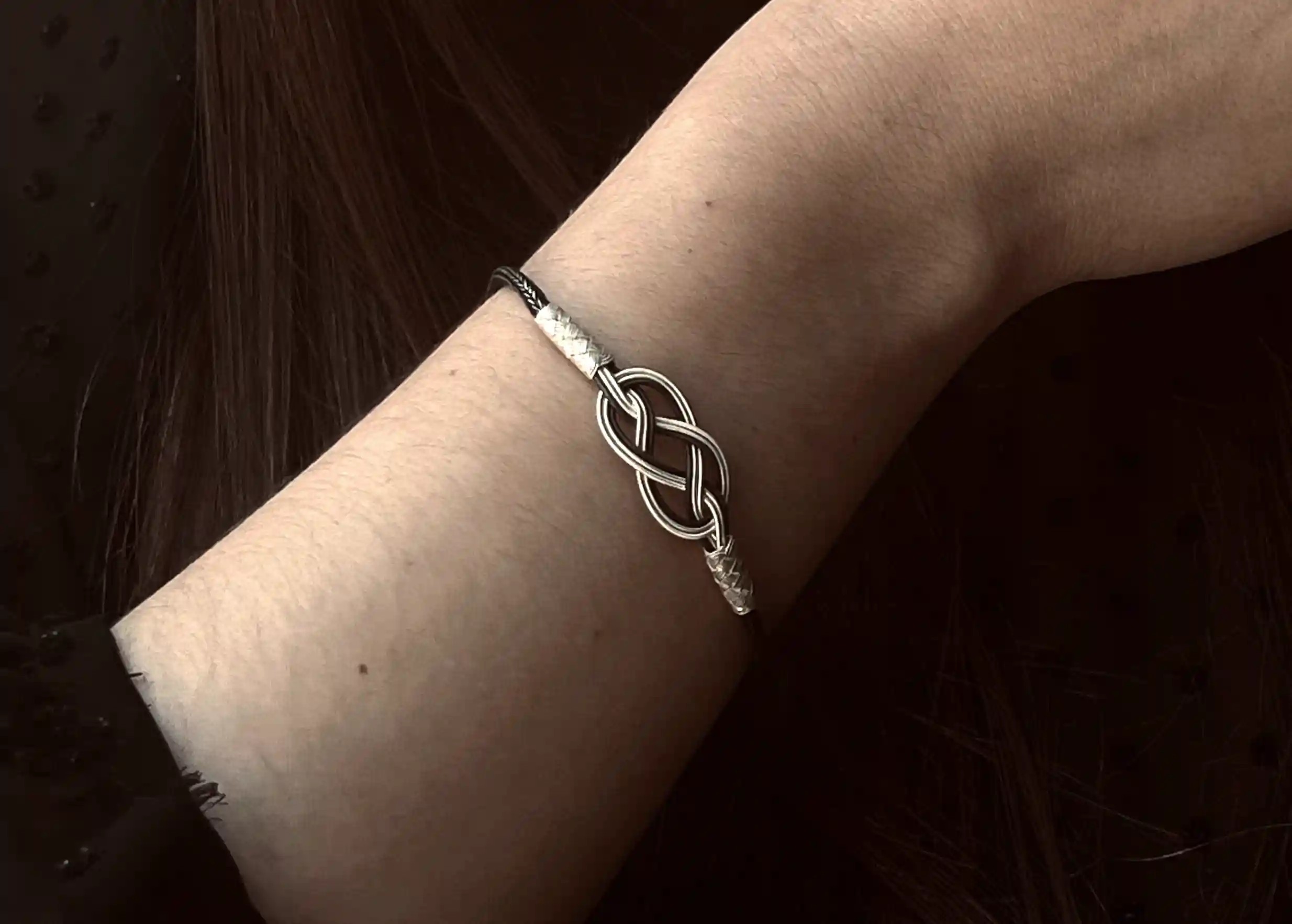 ‘Infinity’ bracelet model, silver and silver oxidized from the jewellery collection, handmade and worn by a woman