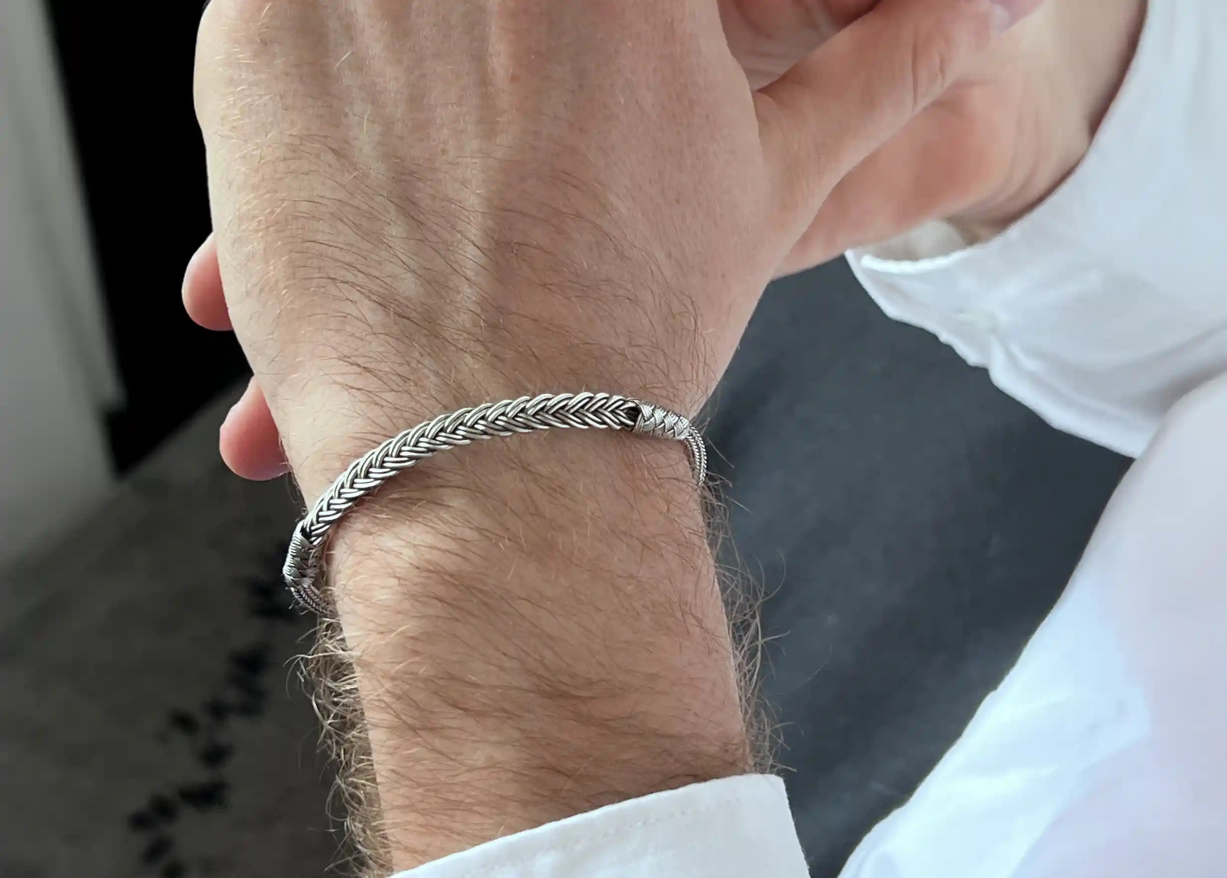 Silver bracelet from the Kokaz jewellery collection, fine plait design, worn on a man's wrist