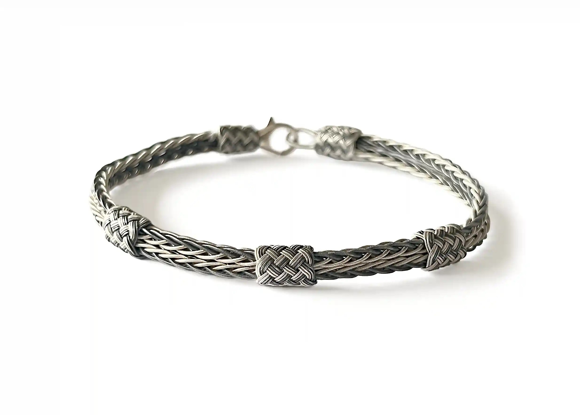 Silver bracelet from the Kokaz jewellery collection double fine braid and 3 knots on white background
