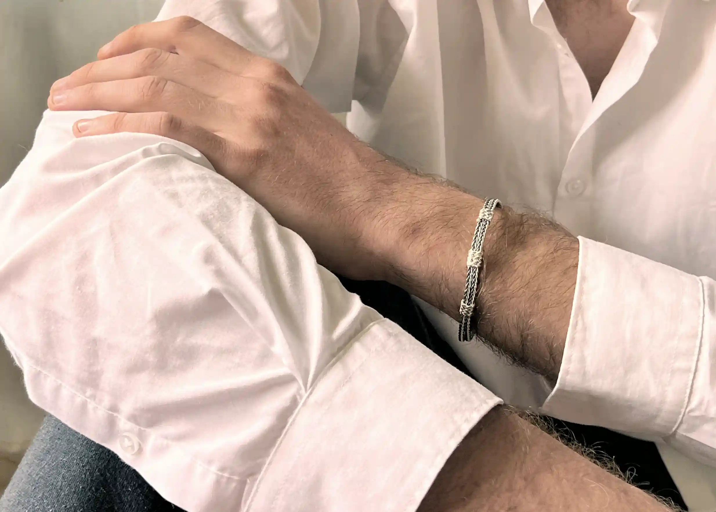 Silver bracelet from the Kokaz jewellery collection double fine braid and 3 knots, worn by a man